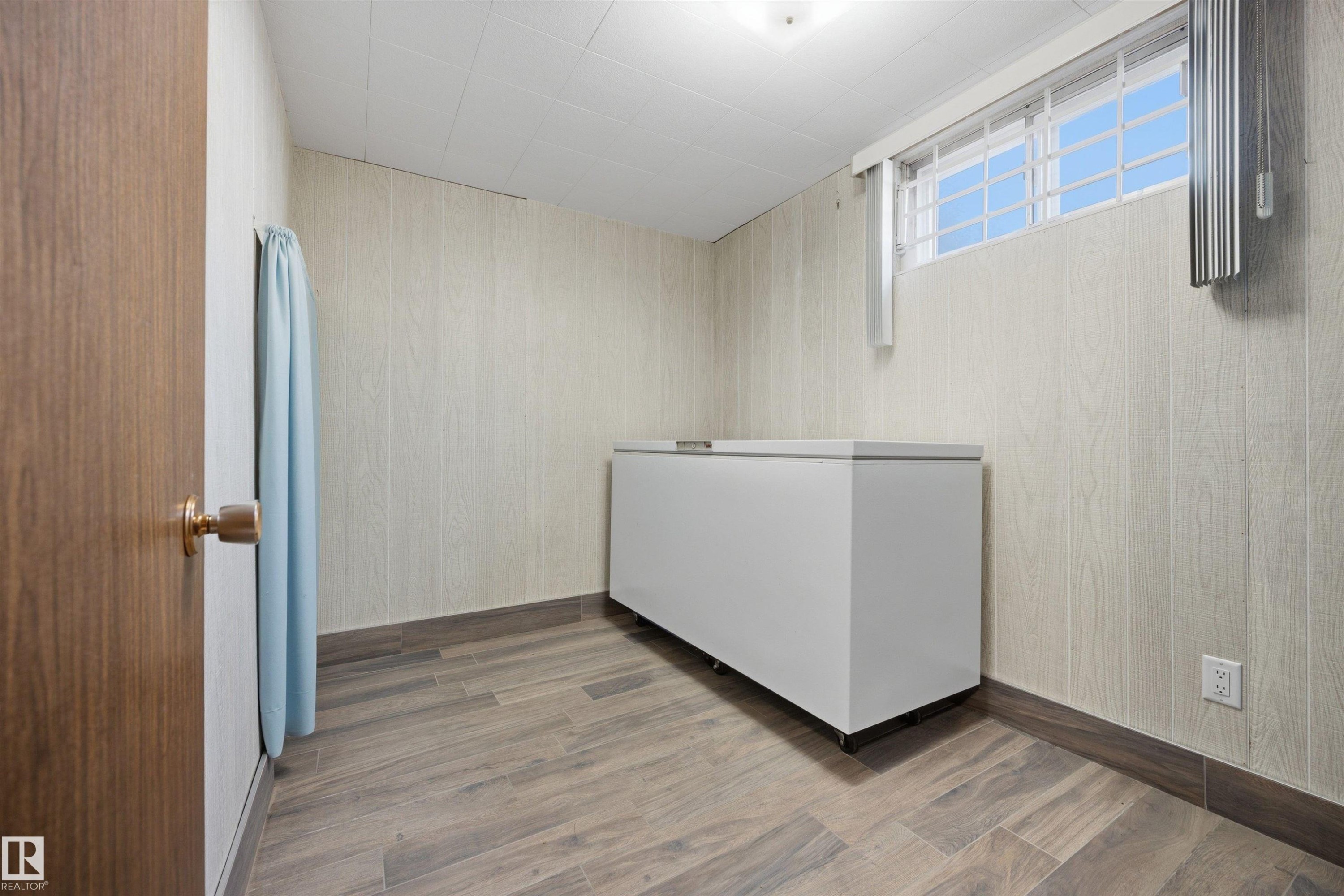 Wood-finish flooring, paneled wall finish, and a window with blinds - 14008 94 Street Nw, Edmonton, AB