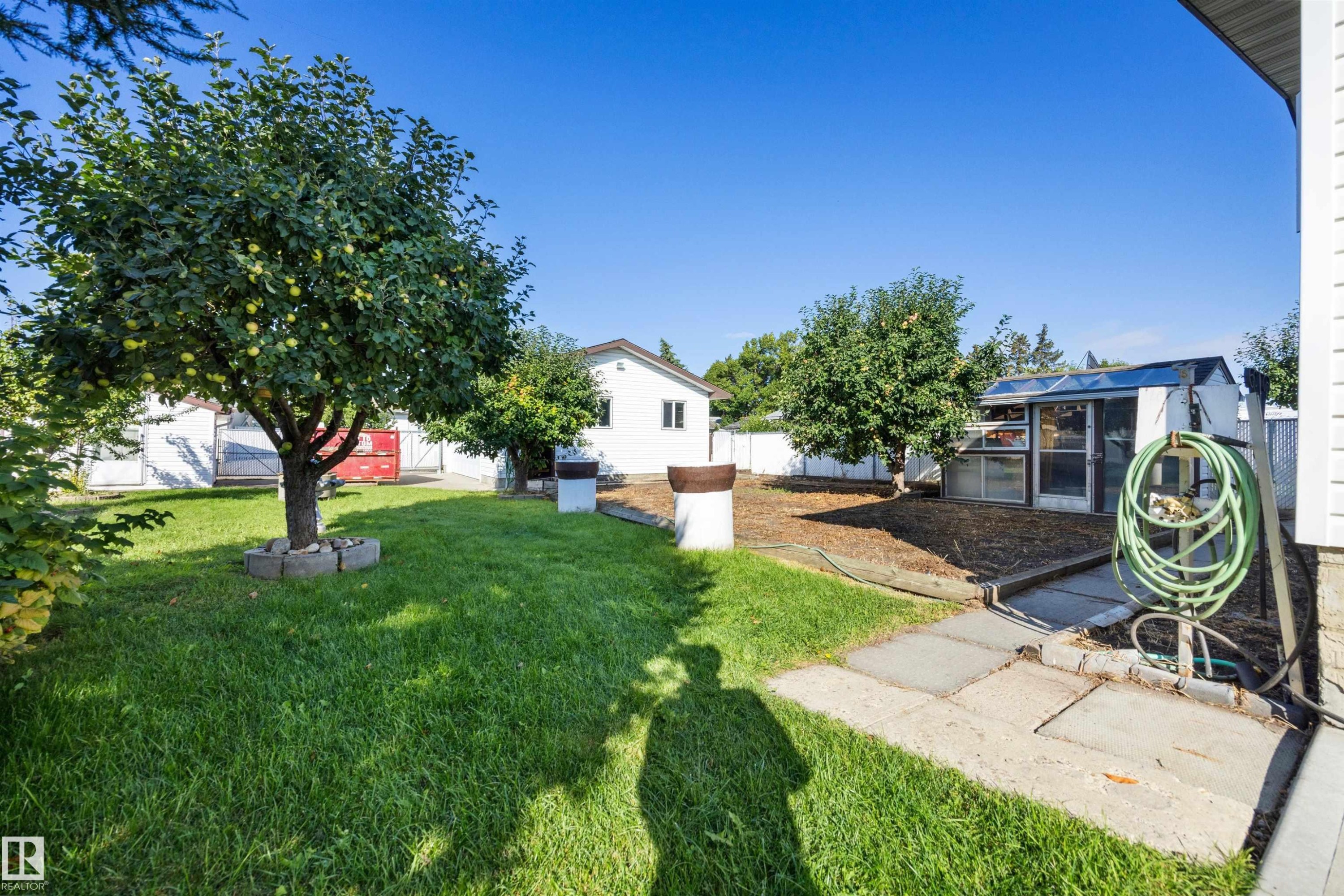 Expansive lawn with mature trees and a greenhouse structure - 14008 94 Street Nw, Edmonton, AB