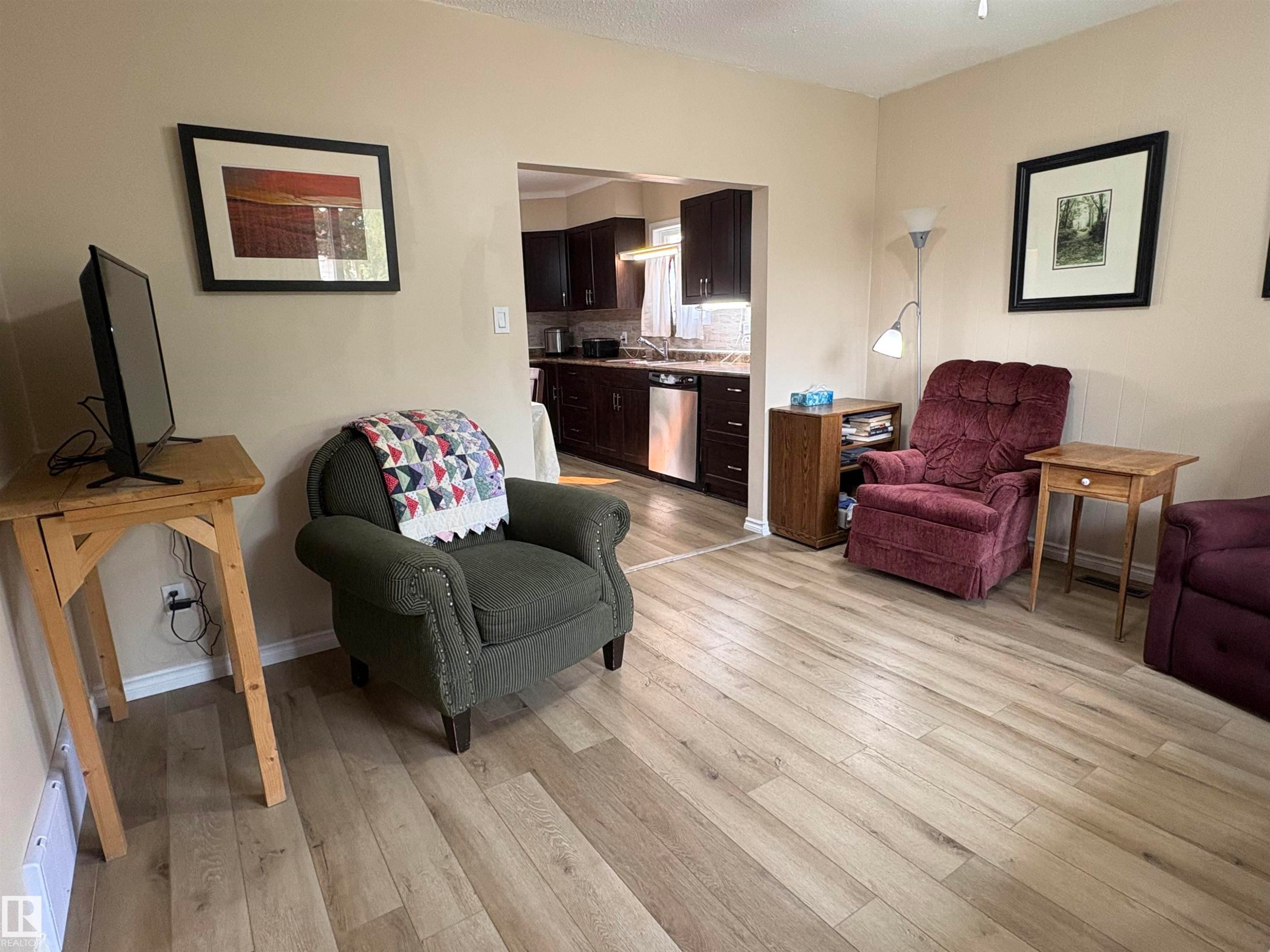 Open concept living area featuring light wood-finish flooring and neutral wall tones - 5308 50 St, Ryley, AB