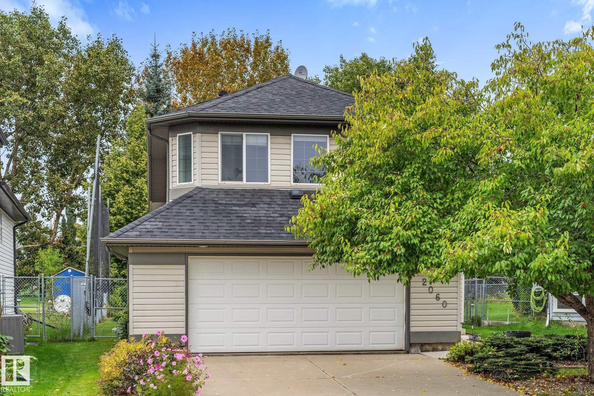 Two-story residence featuring light-colored horizontal siding and a dark shingle roof - 2060 Brennan Crescent Nw, Edmonton, AB