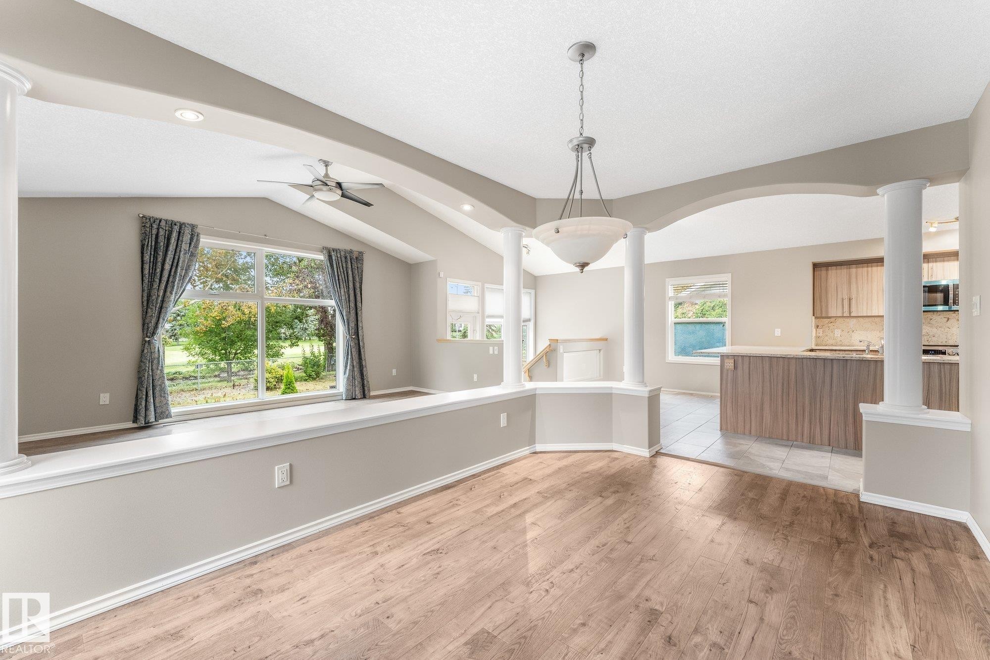 Vaulted ceiling with a ceiling fan, wood-finish flooring, recessed lighting, decorative columns, and an arched entryway - 2060 Brennan Crescent Nw, Edmonton, AB
