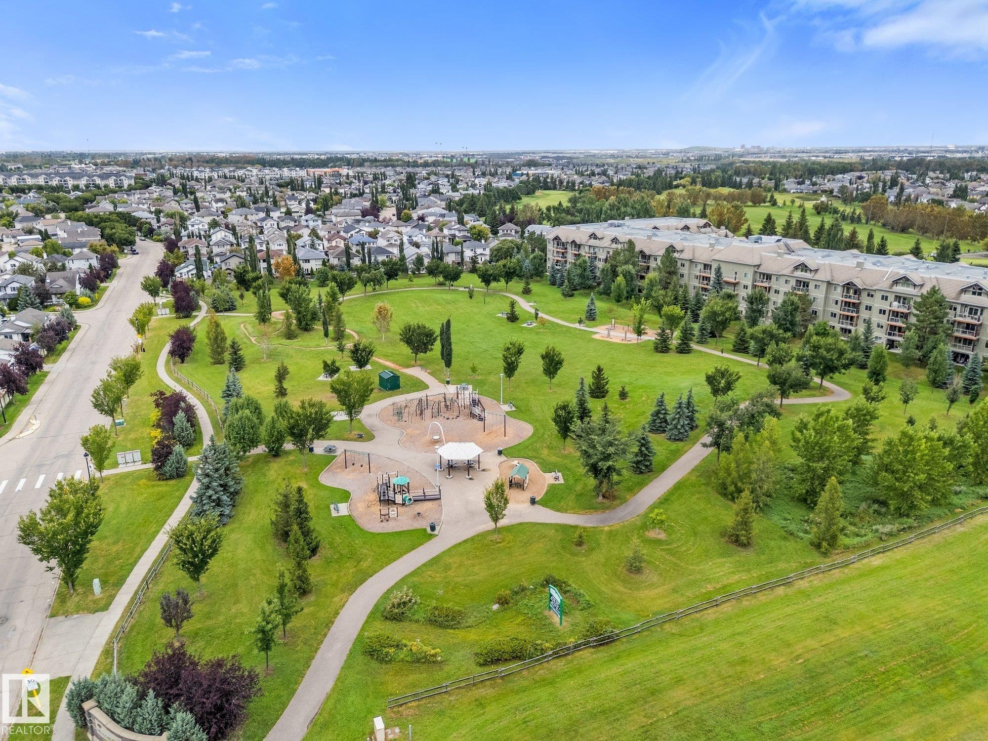 Expansive green space featuring a playground, walking paths, and mature trees - 2060 Brennan Crescent Nw, Edmonton, AB