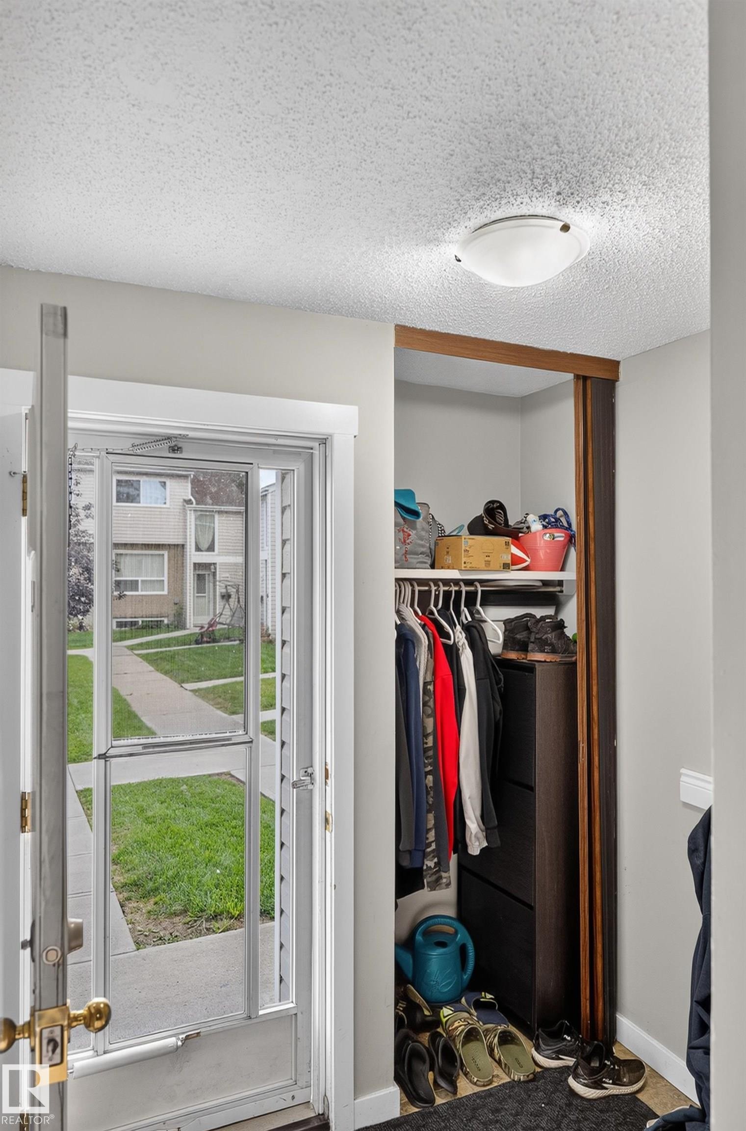 Entryway featuring a built-in closet with shelving and hanging storage - 18319 93 Avenue Nw, Edmonton, AB