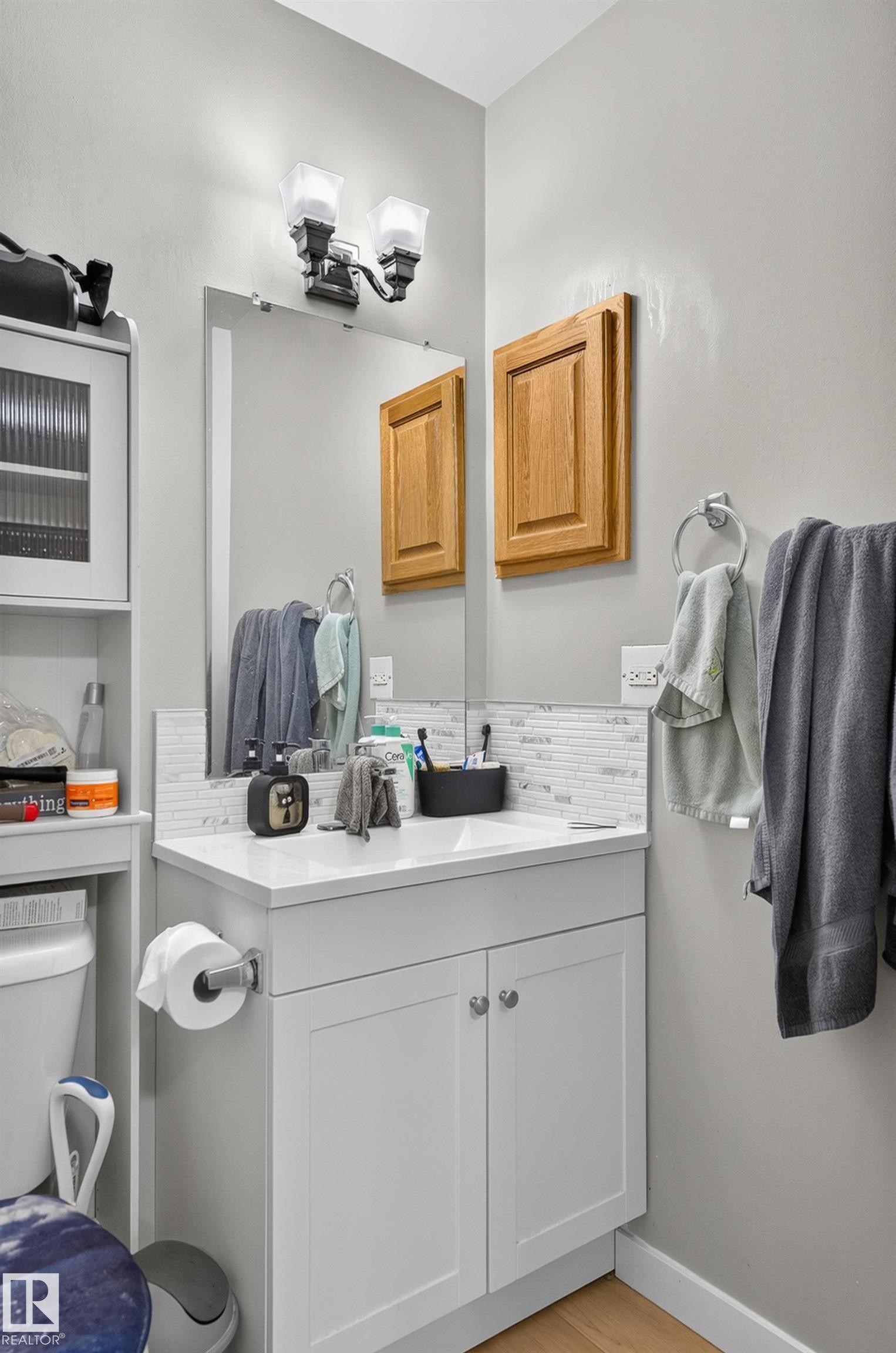 White vanity with dual cabinet doors, integrated sink, and white countertop - 18319 93 Avenue Nw, Edmonton, AB