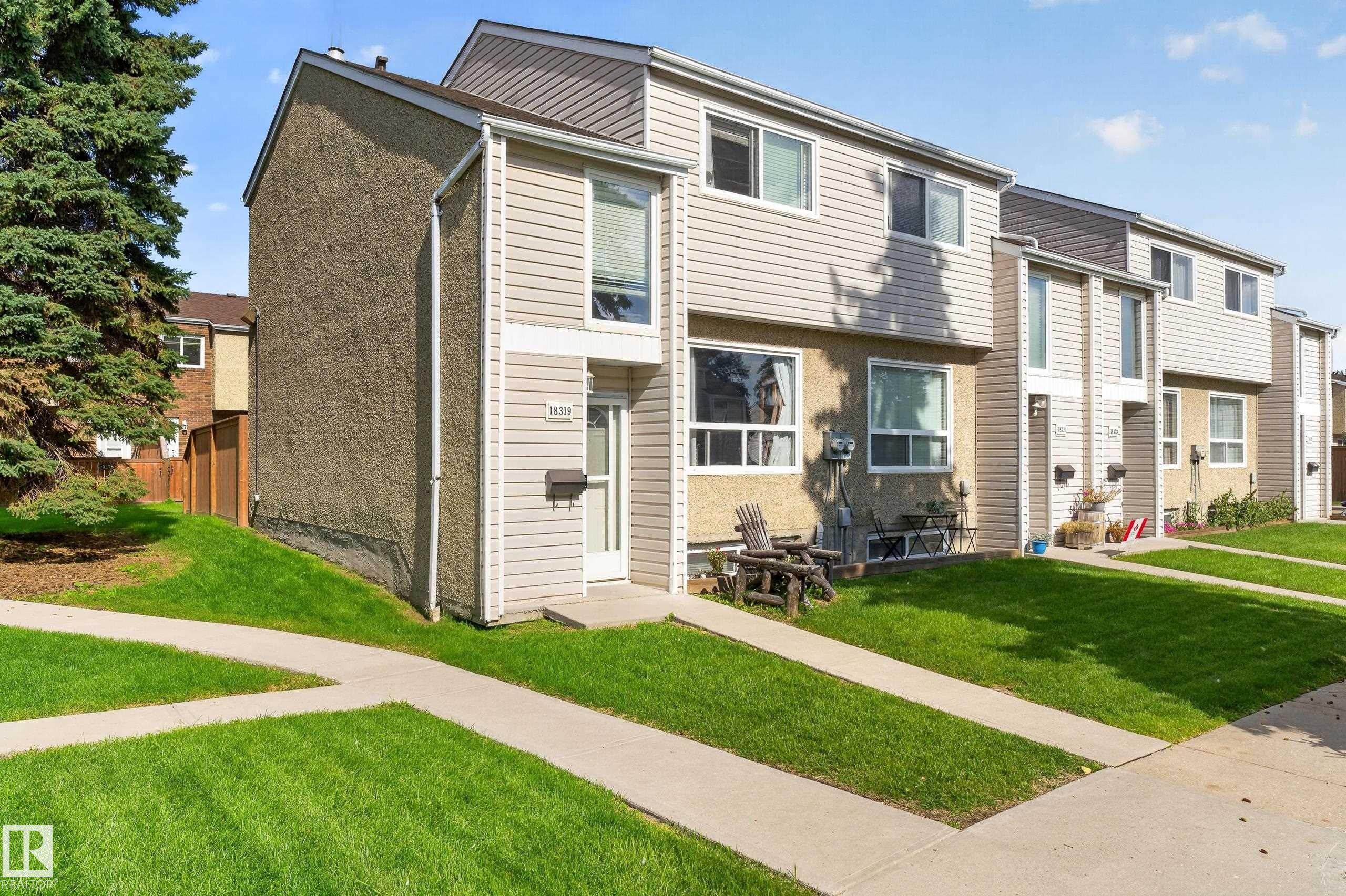 Exterior featuring horizontal siding, stucco elements, and established lawn - 18319 93 Avenue Nw, Edmonton, AB