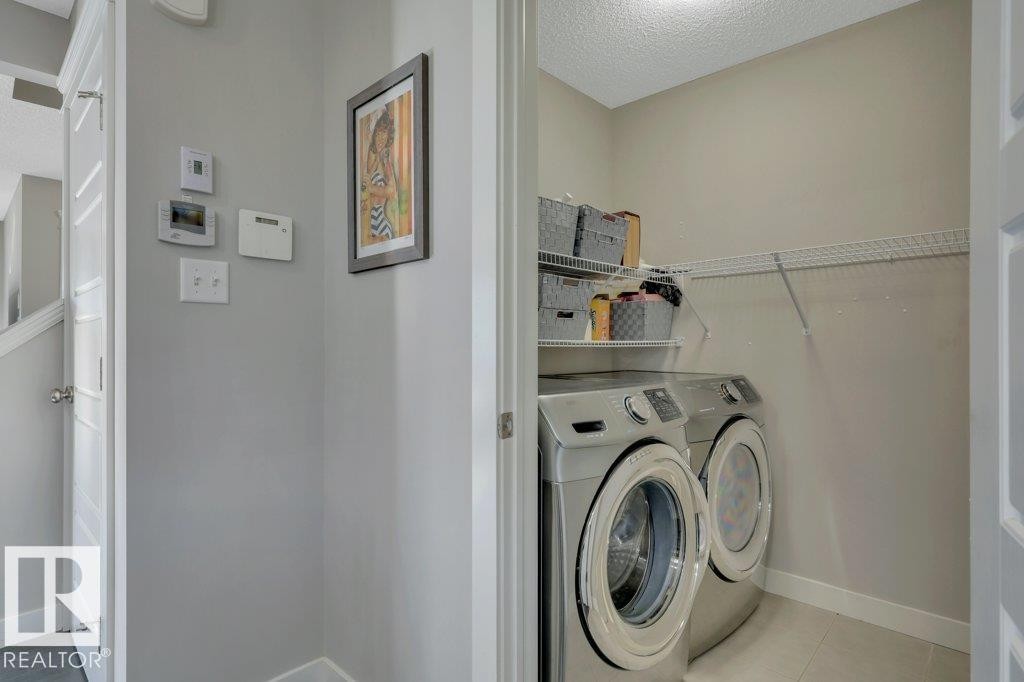 Main floor laundry with ample storage and shelving - 160 Desrochers Gate Sw, Edmonton, AB