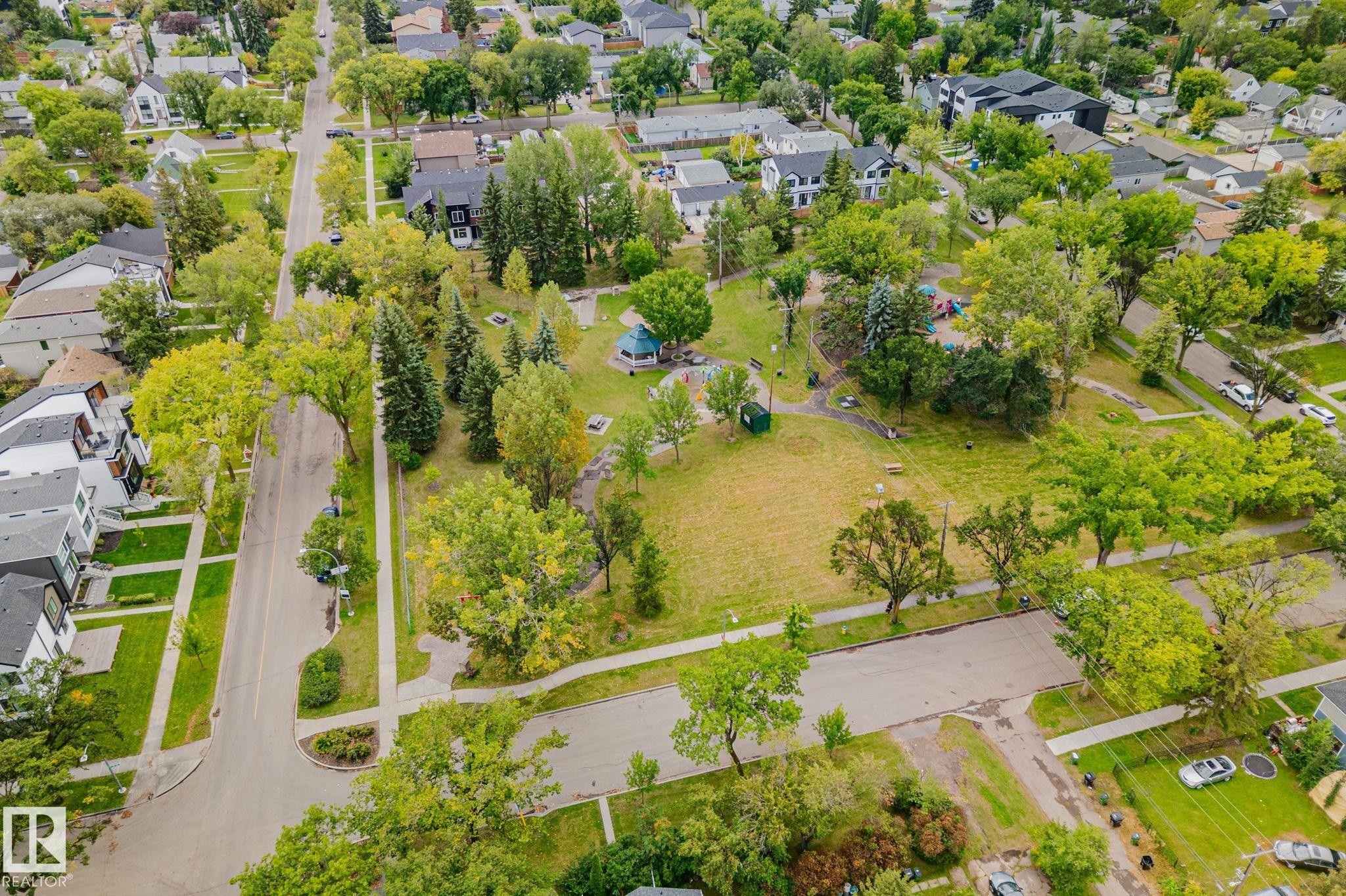 Residential street with sidewalks and mature trees, bordered by green spaces and varying architectural styles - 11935 125 Street Nw, Edmonton, AB