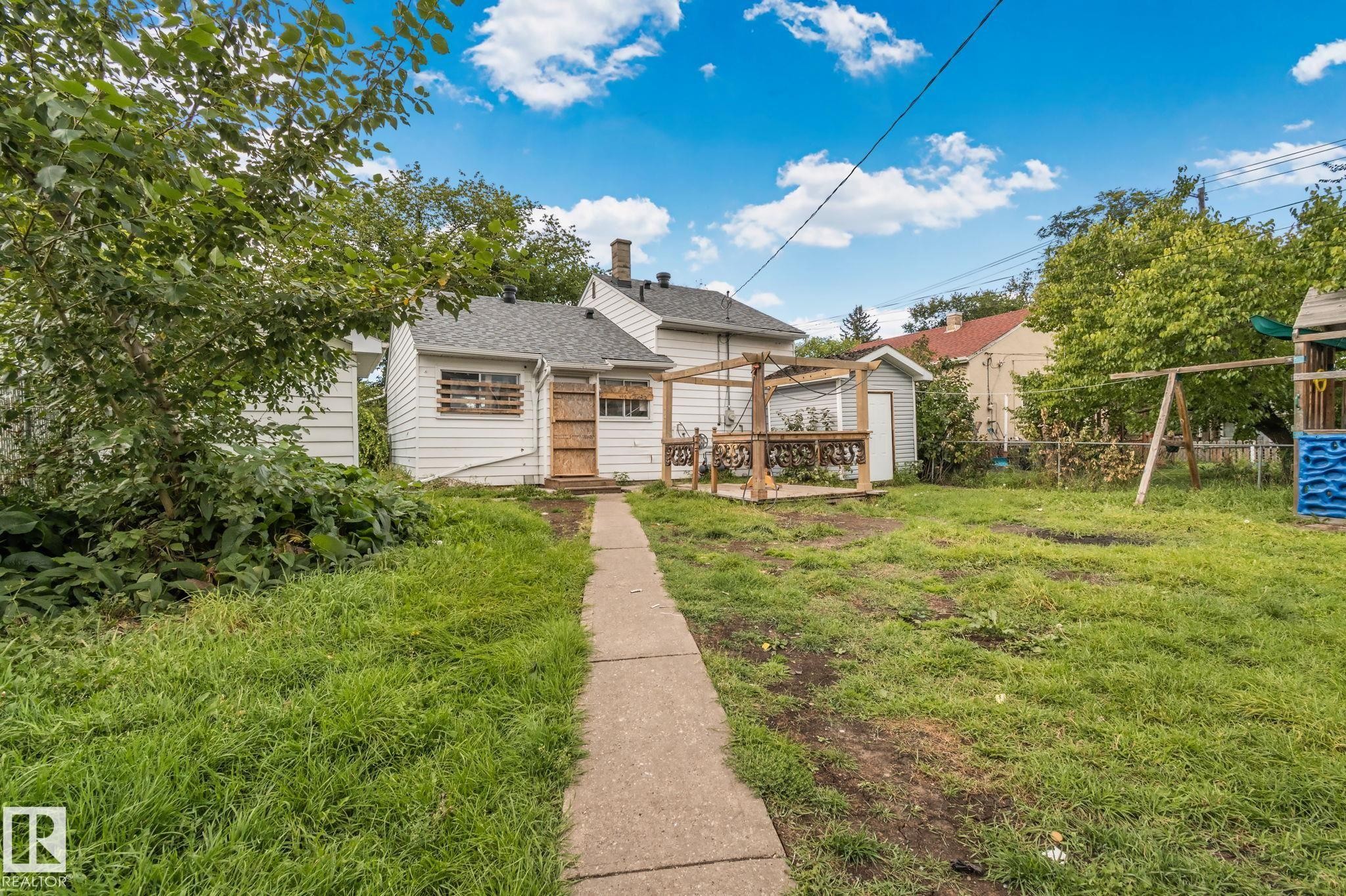 Rear exterior with white siding and a sloped roof - 11935 125 Street Nw, Edmonton, AB