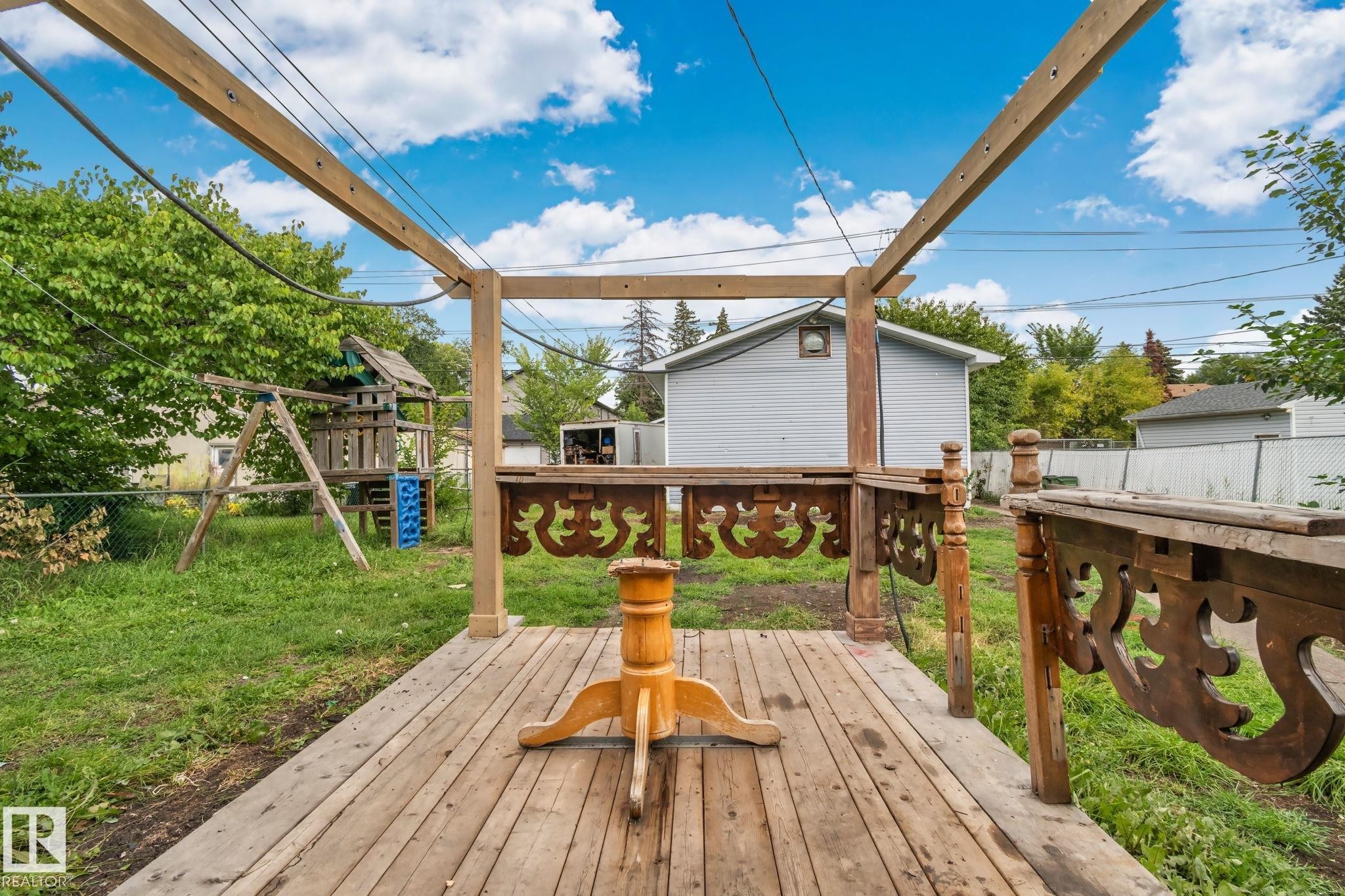 Wood-plank deck with decorative balusters and a partial pergola frame - 11935 125 Street Nw, Edmonton, AB