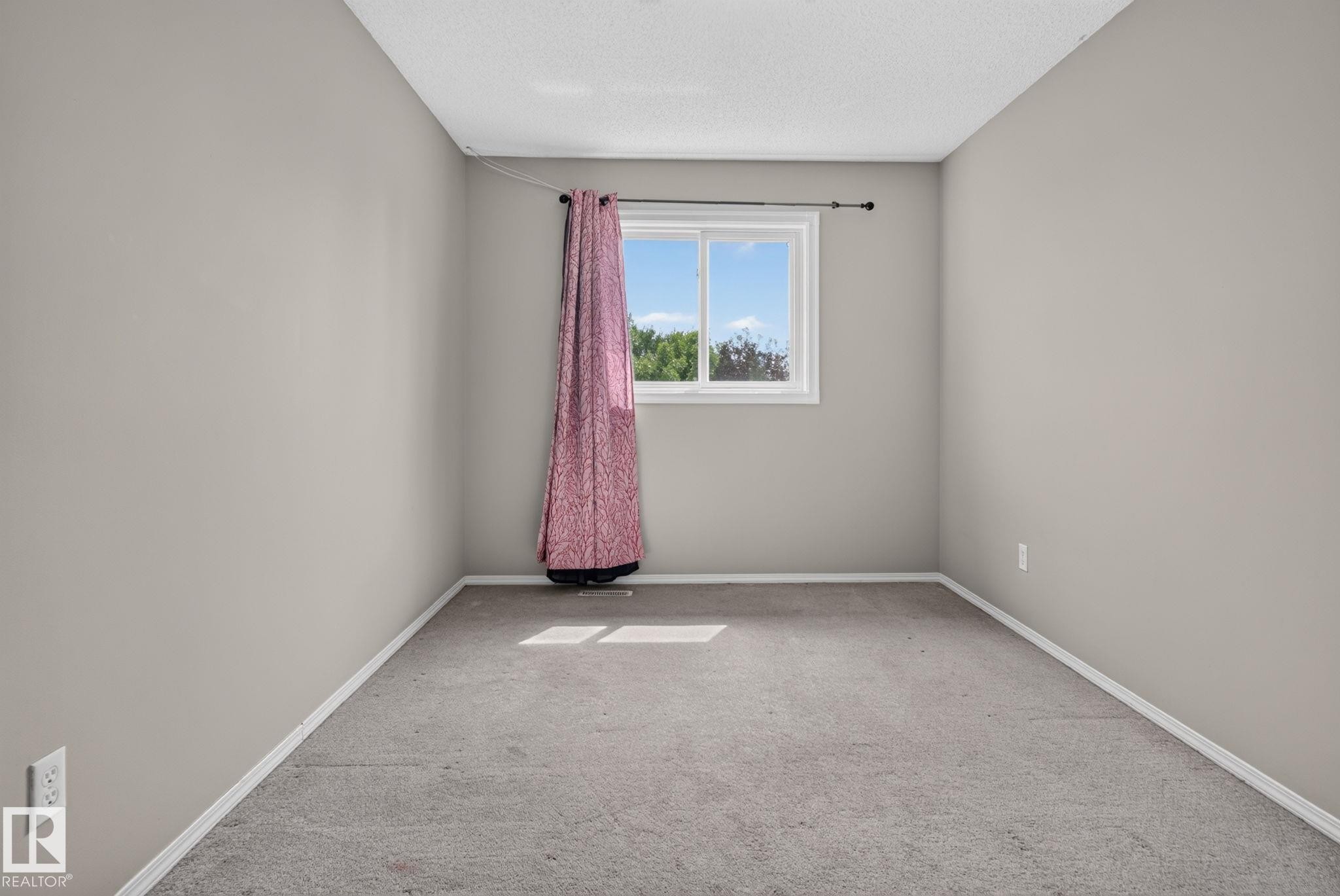 Neutral wall color, carpeted flooring, and a window providing natural illumination - 8923 173 Avenue Nw, Edmonton, AB
