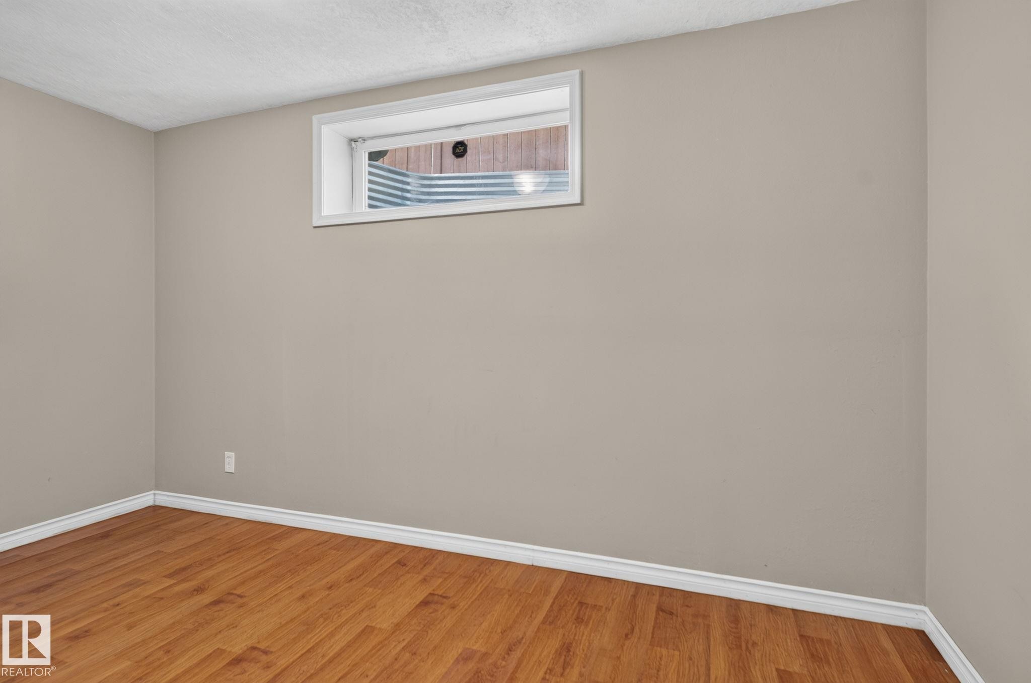 Wood-finish flooring, neutral wall paint, and white trim - 8923 173 Avenue Nw, Edmonton, AB
