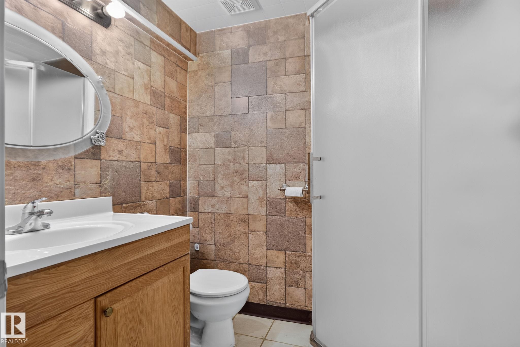 Vanity with wood-finish cabinetry and integrated sink - 8923 173 Avenue Nw, Edmonton, AB