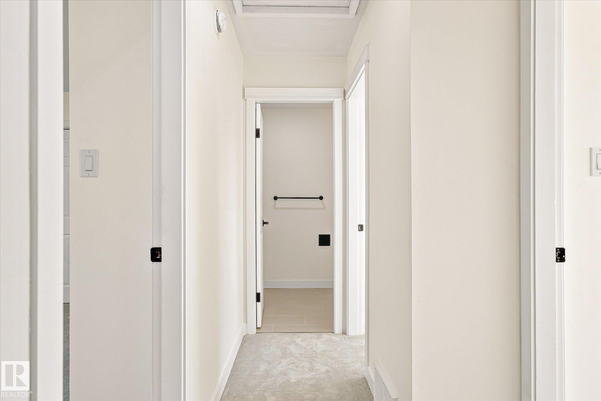 Hallway with neutral wall tones and light-colored carpeting - 17325 85 Avenue Nw, Edmonton, AB