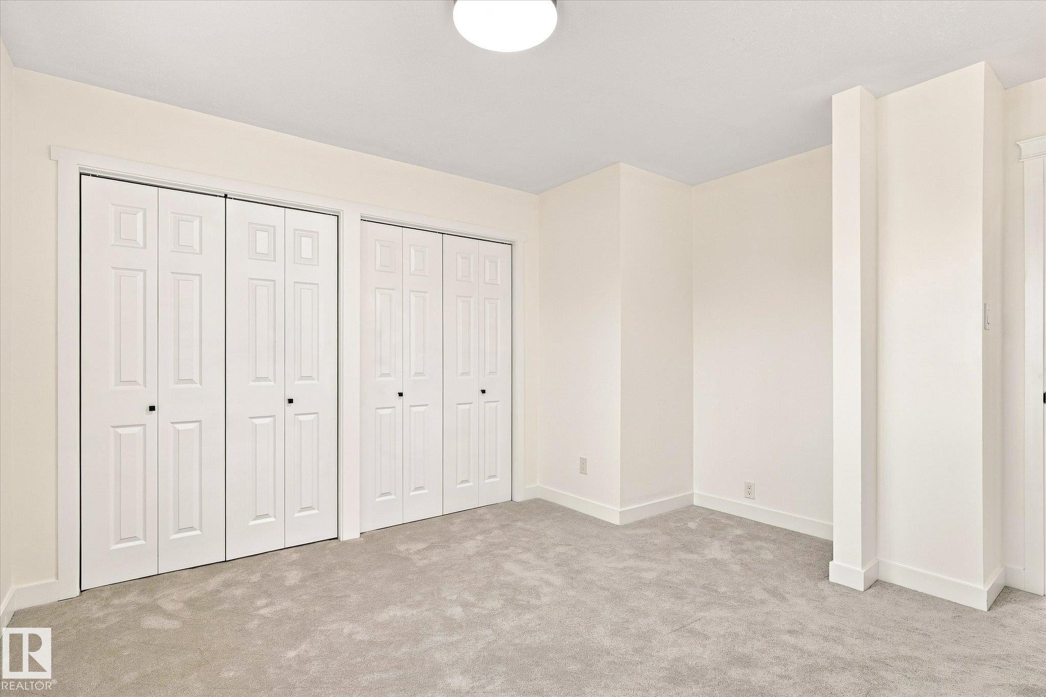 Neutral wall finishes, plush carpet flooring, recessed ceiling lighting, and multiple bi-fold closet doors - 17325 85 Avenue Nw, Edmonton, AB