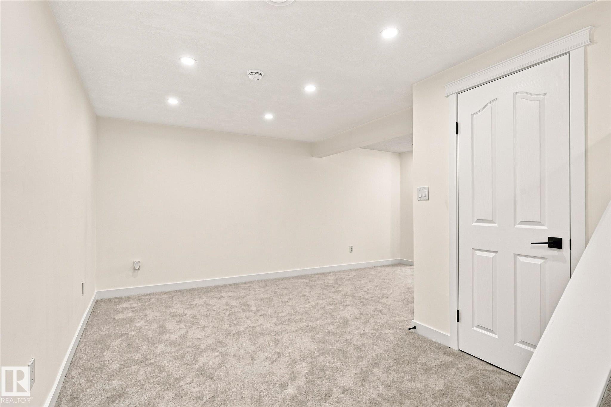 Recessed ceiling lighting, light gray carpet, white interior door with black hardware, and light-toned walls - 17325 85 Avenue Nw, Edmonton, AB