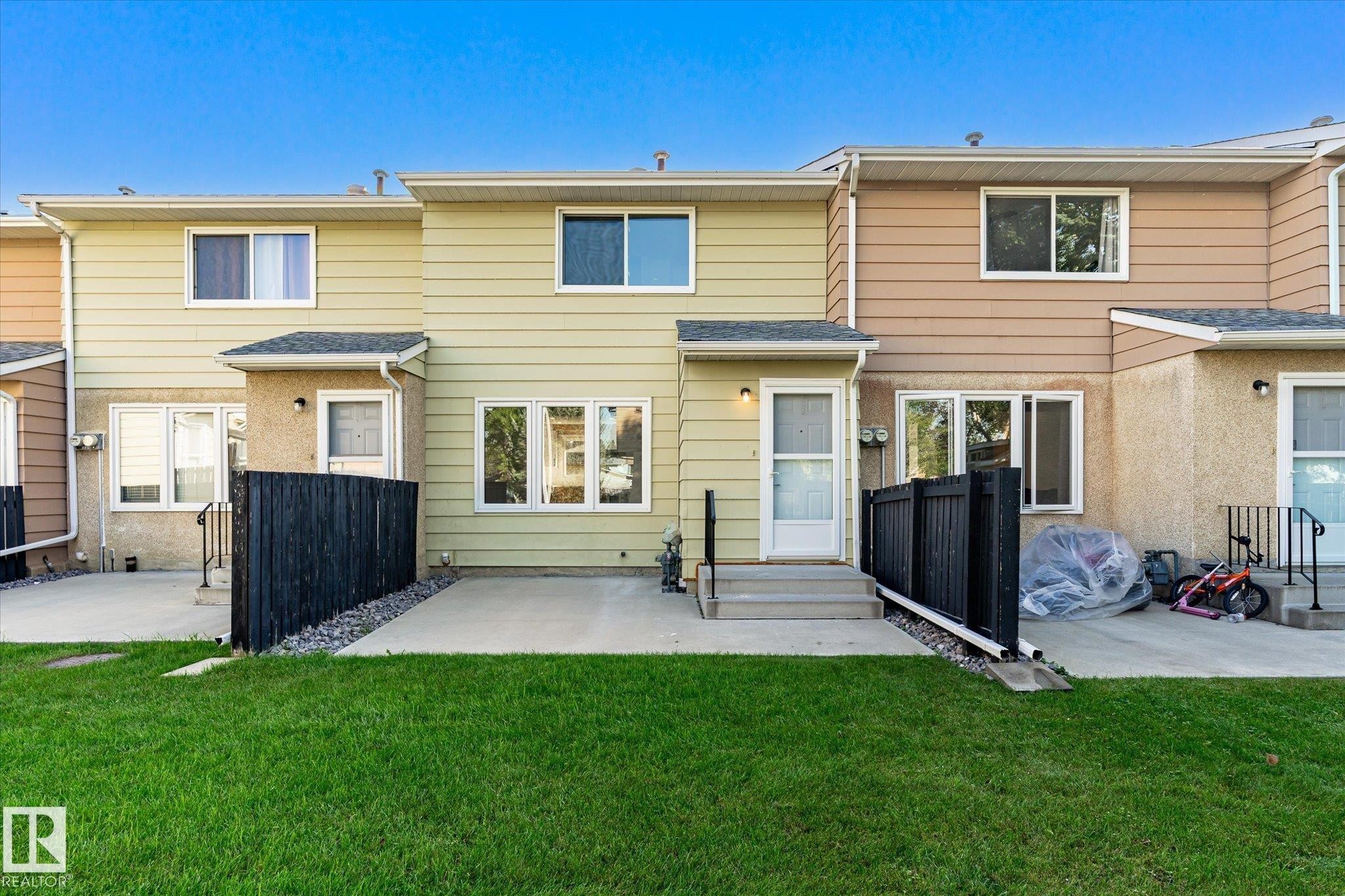 Expansive green lawn, concrete patio, and a privacy fence - 17325 85 Avenue Nw, Edmonton, AB