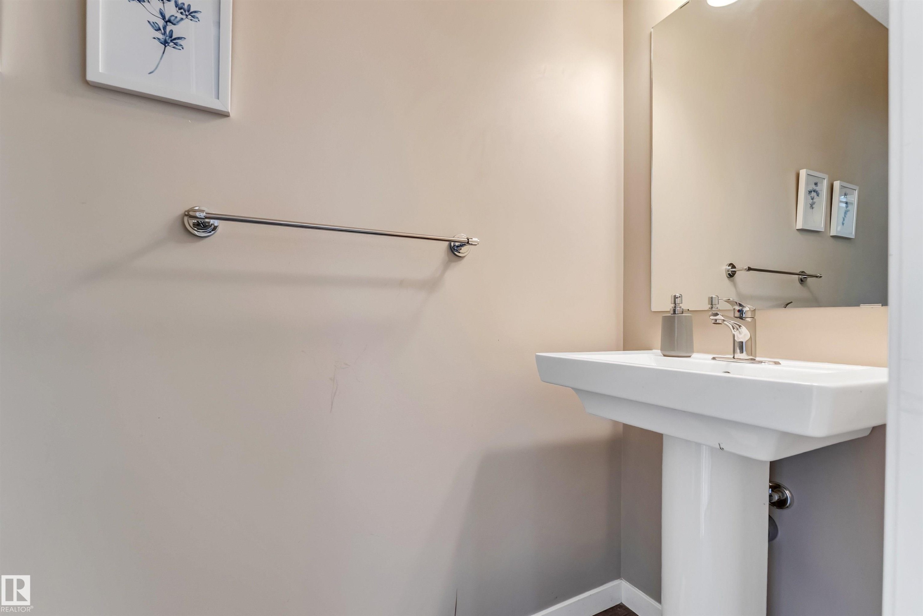 Pedestal sink with chrome faucet, complemented by a wall-mounted mirror - 1514 26 Avenue Nw, Edmonton, AB - Indoor Photo Showing Other Room