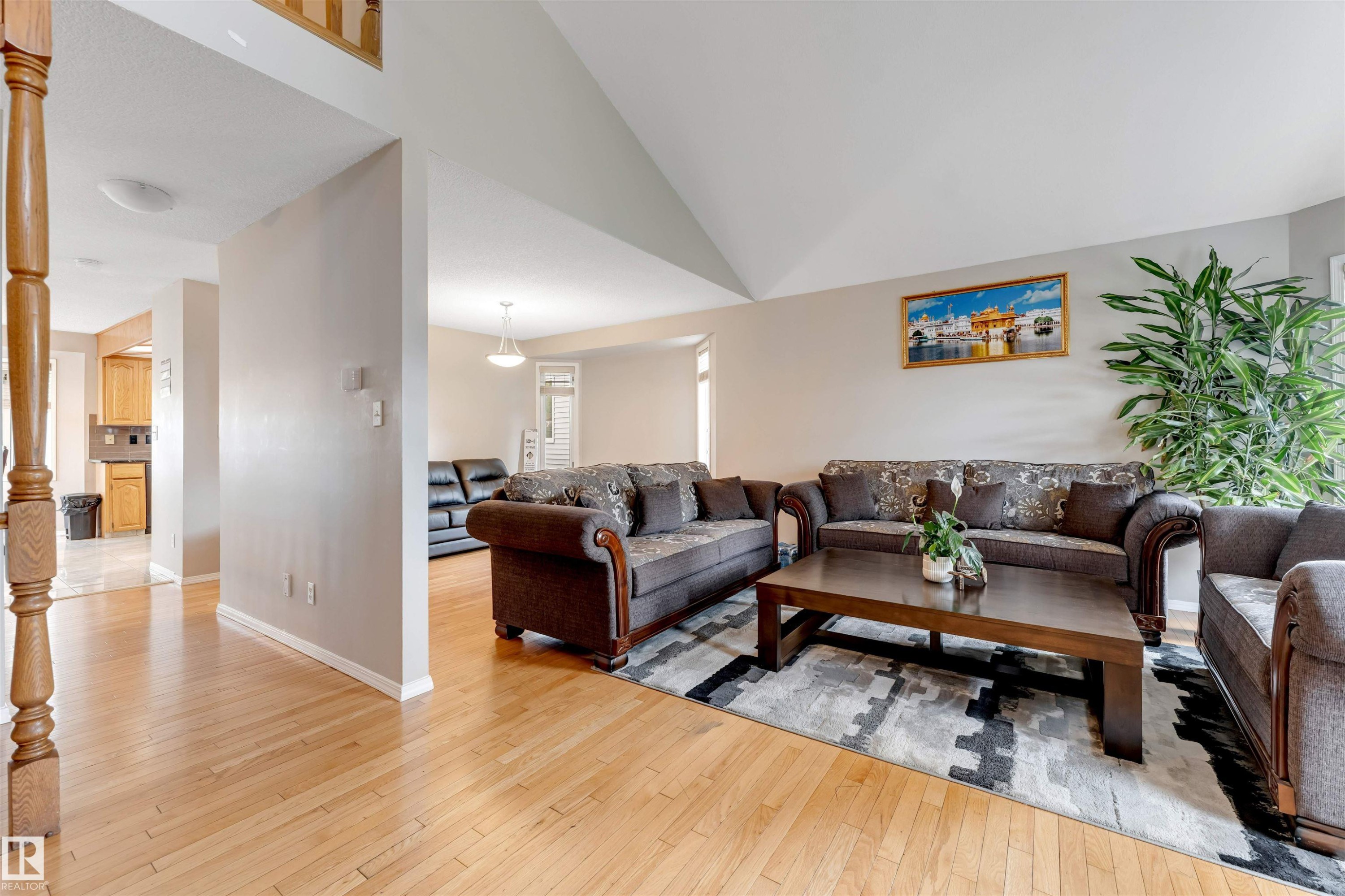 Living area featuring vaulted ceilings, light wood-finish flooring, and neutral wall tones - 4465 32A Street Nw, Edmonton, AB - Indoor Photo Showing Living Room