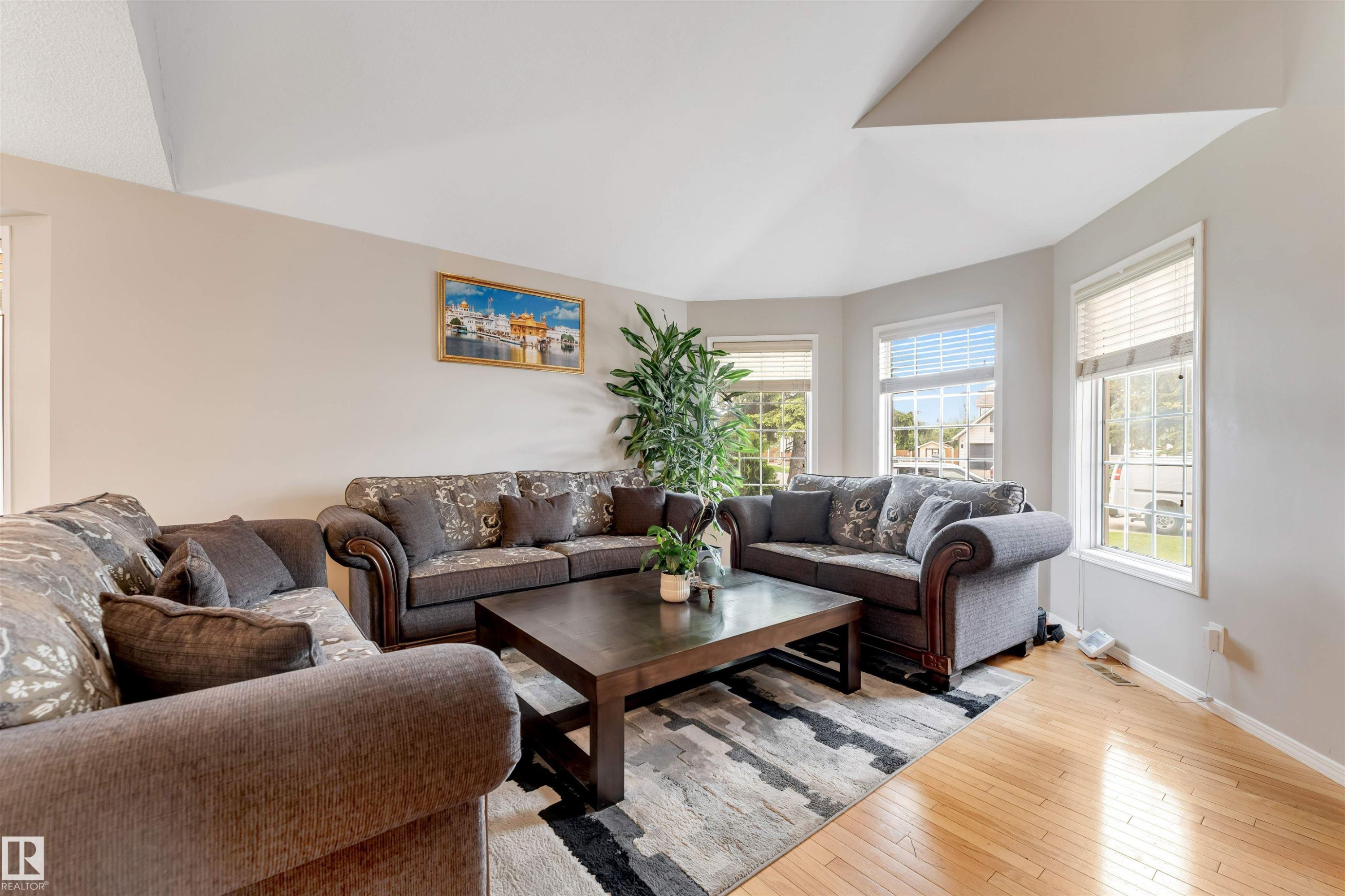 Living space featuring bay windows, light wood-finish flooring, and a vaulted ceiling - 4465 32A Street Nw, Edmonton, AB - Indoor Photo Showing Living Room