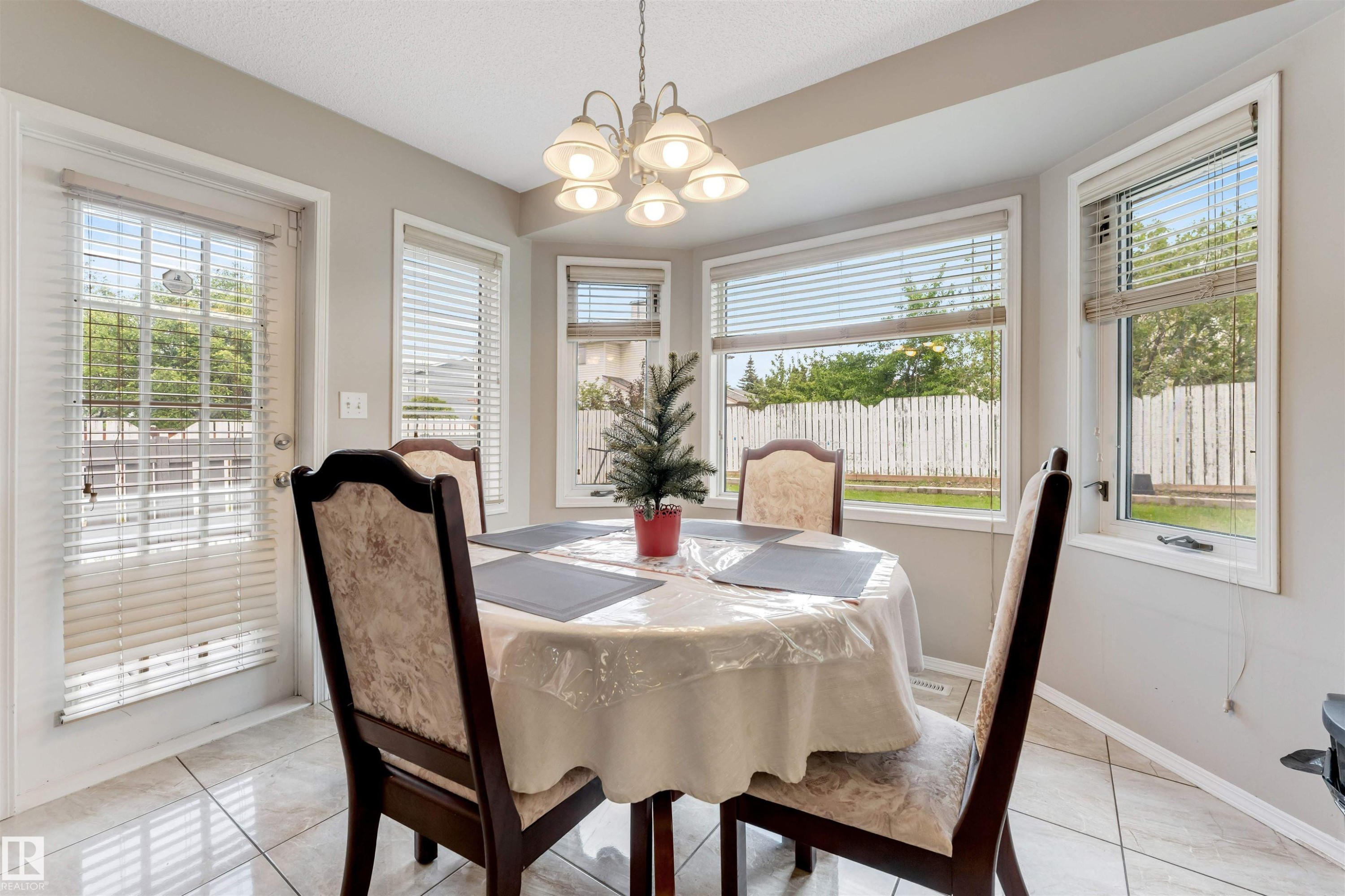 Breakfast nook with tiled flooring, a multi-window bay, and a glass-paneled exterior door - 4465 32A Street Nw, Edmonton, AB - Indoor Photo Showing Dining Room