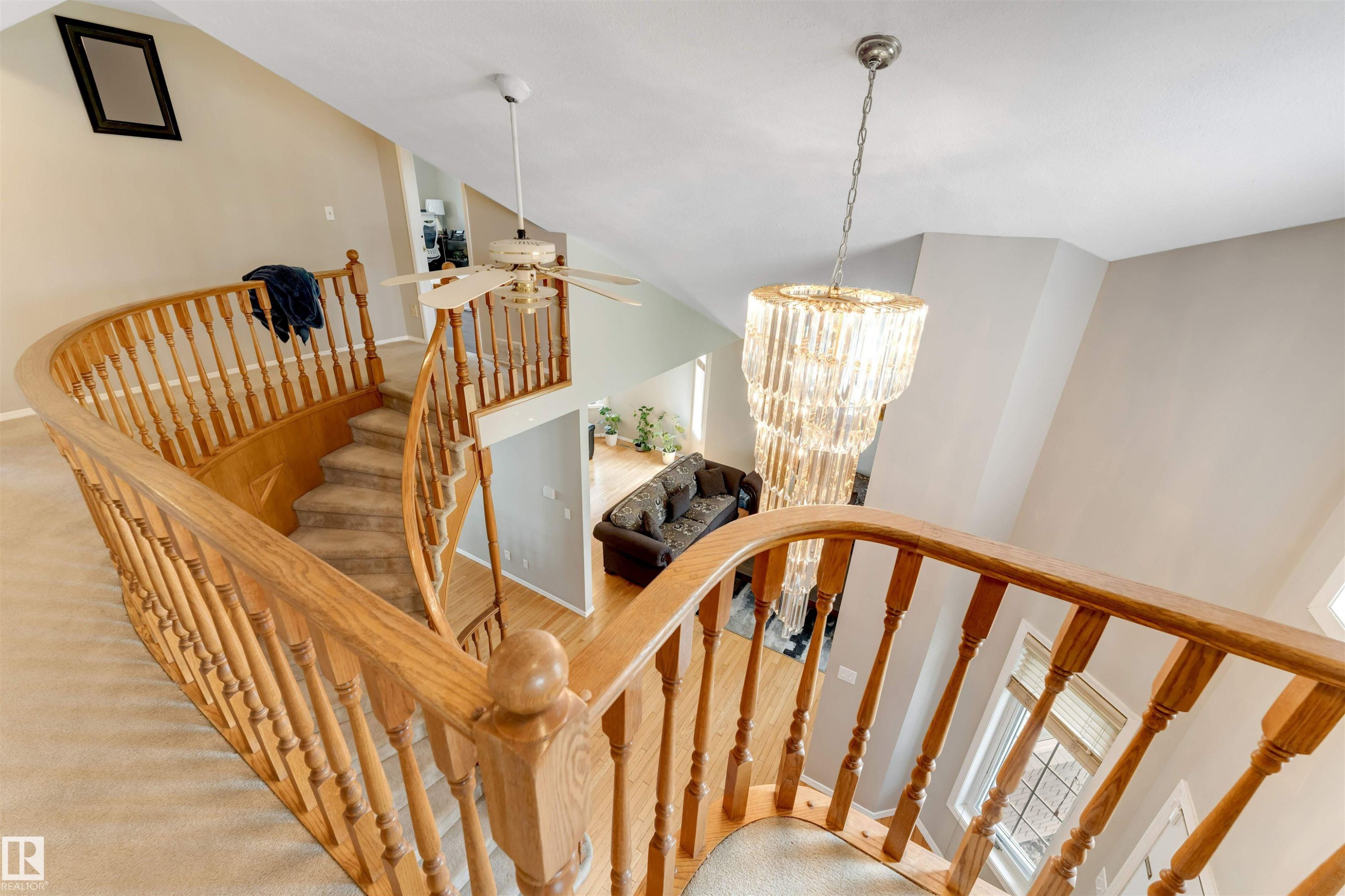 Curved staircase featuring wood banisters and carpeted treads - 4465 32A Street Nw, Edmonton, AB - Indoor Photo Showing Other Room