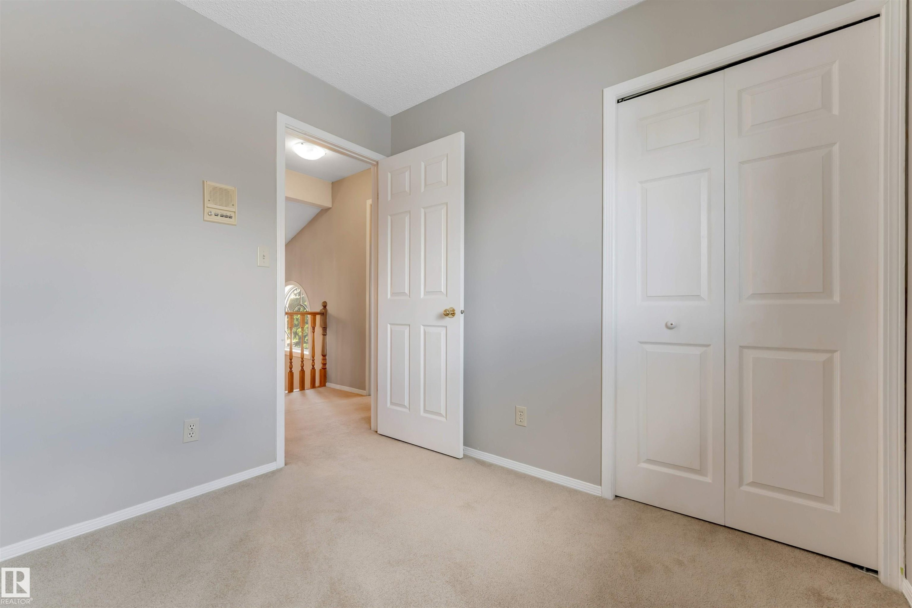 Neutral-toned wall paneling and a light-colored carpet flooring - 4465 32A Street Nw, Edmonton, AB - Indoor Photo Showing Other Room
