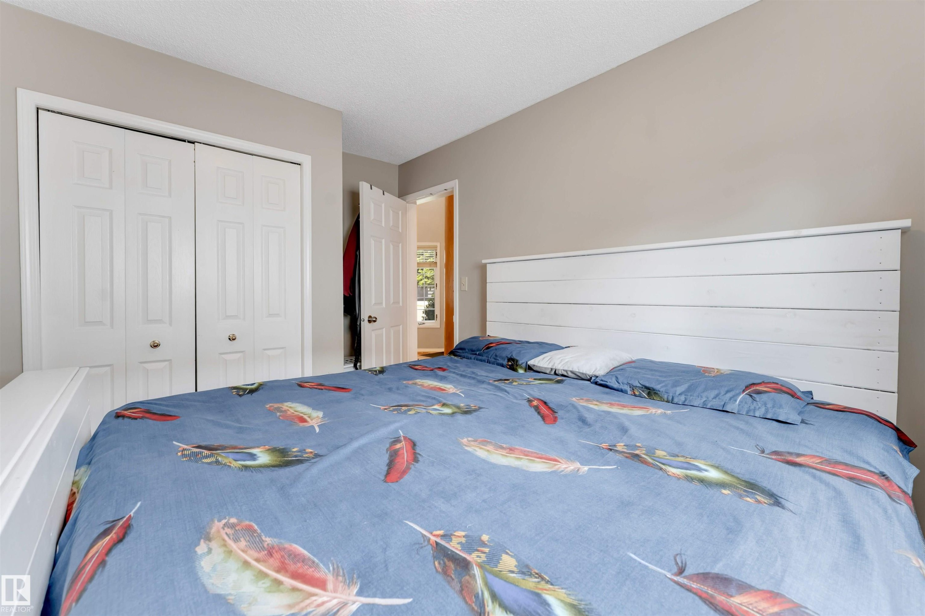 Bedroom featuring neutral wall paint, white trim, and a textured ceiling - 4465 32A Street Nw, Edmonton, AB - Indoor Photo Showing Bedroom