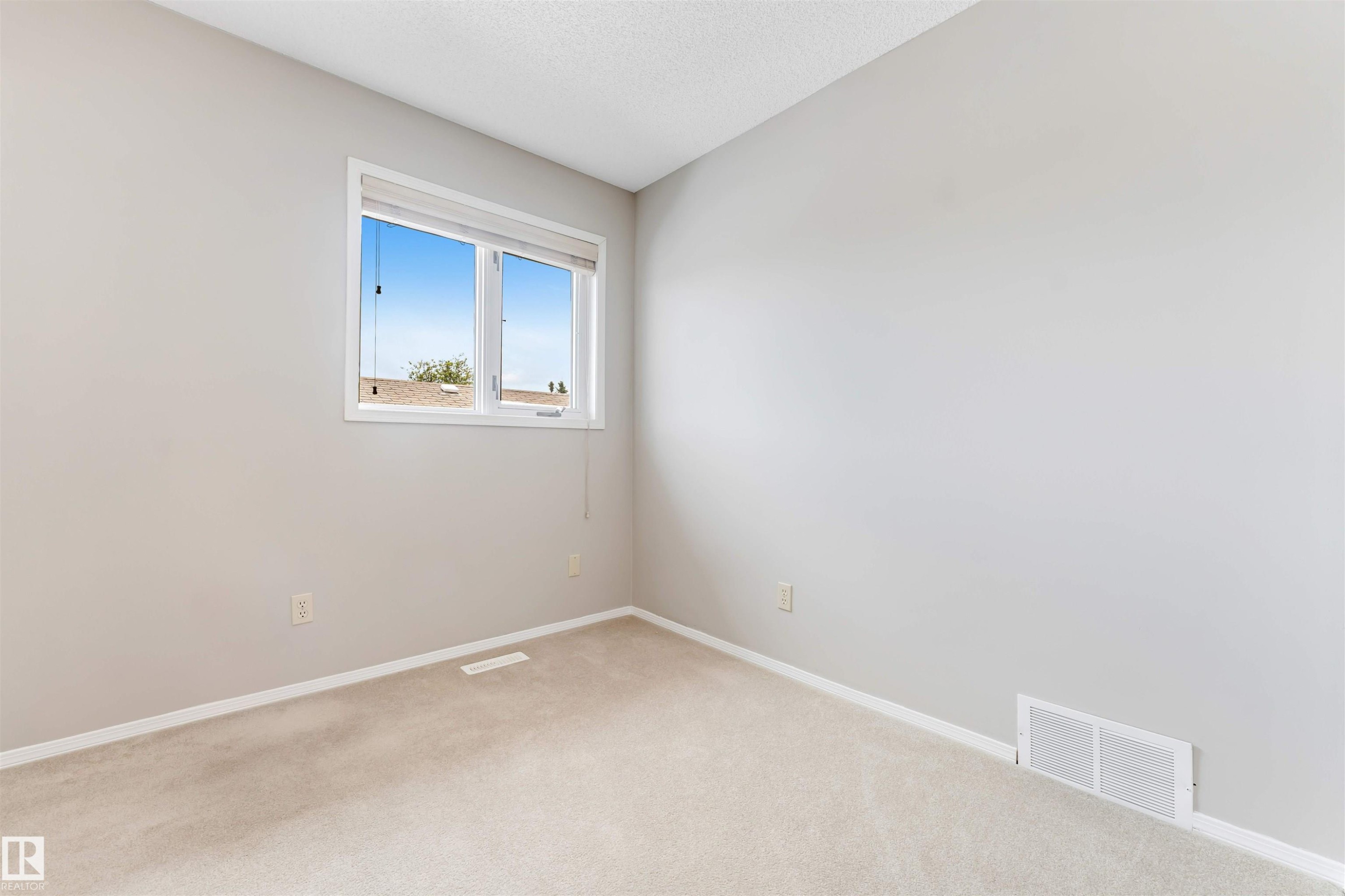 Light-filled room featuring neutral wall paint, white trim, and a window offering outdoor scenery - 4465 32A Street Nw, Edmonton, AB - Indoor Photo Showing Other Room