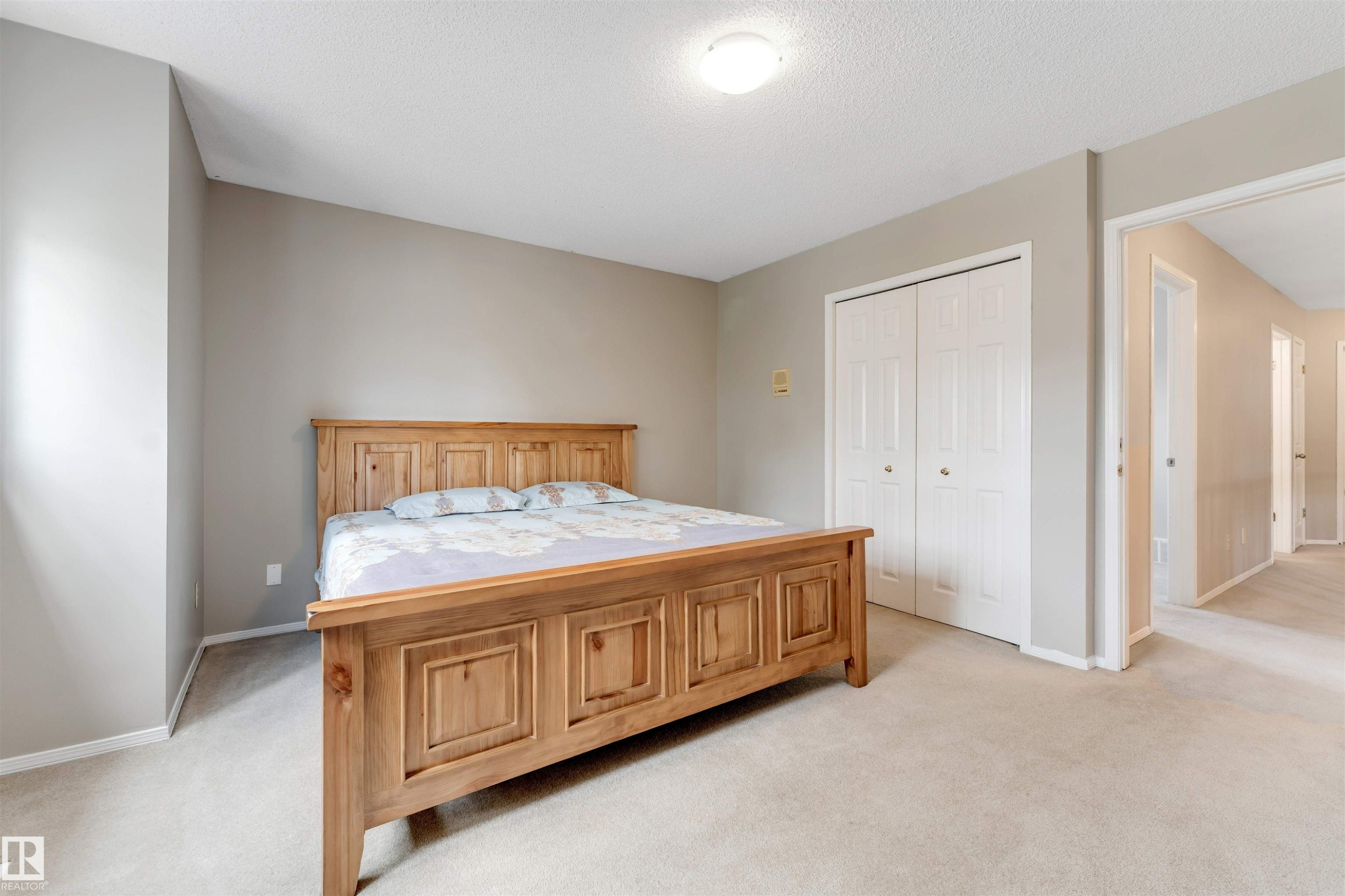 Carpeted bedroom with neutral wall tones and a textured ceiling - 4465 32A Street Nw, Edmonton, AB - Indoor Photo Showing Bedroom