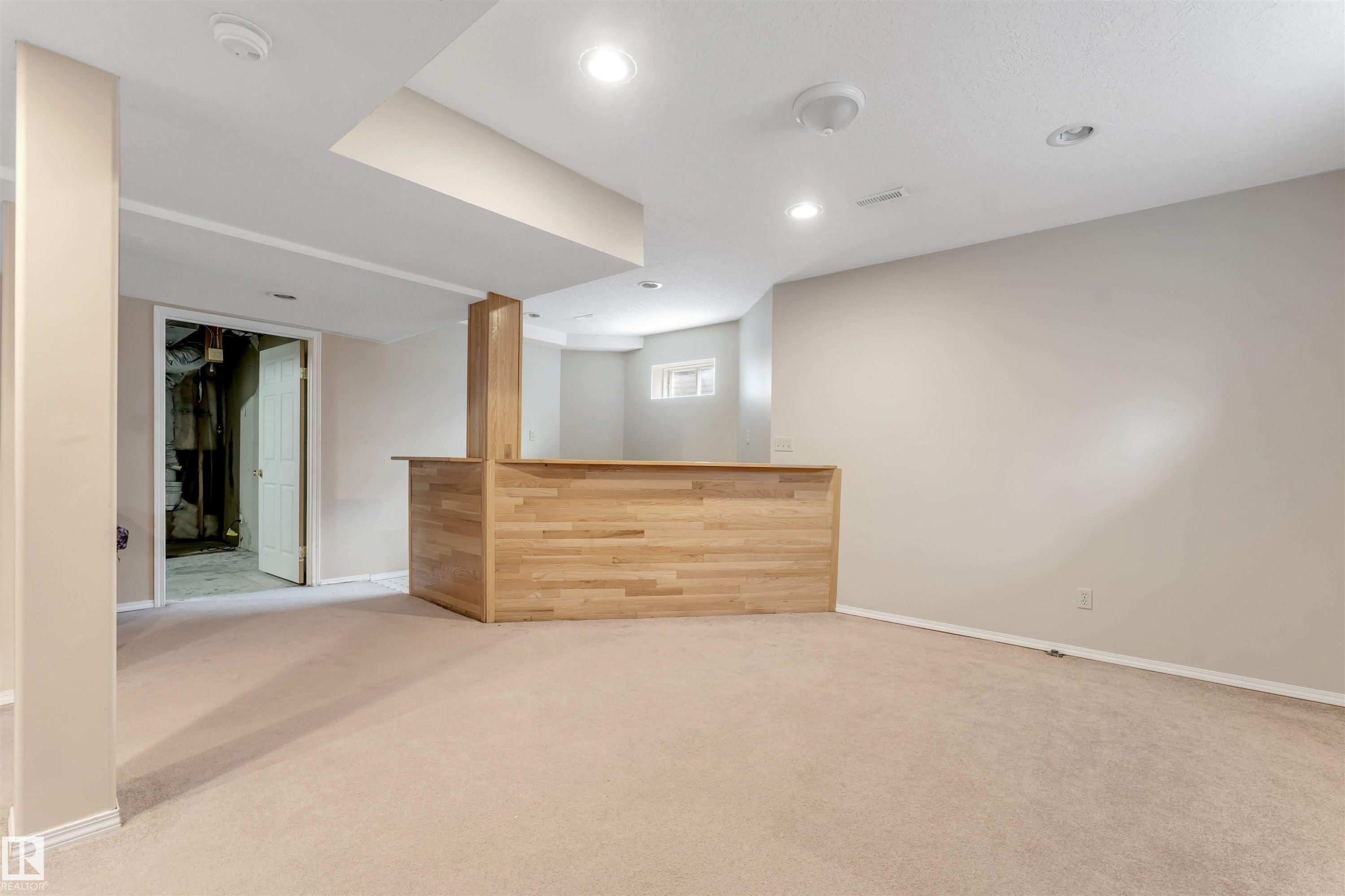 Finished lower level featuring a built-in wood-finish bar, recessed lighting, and neutral carpeting - 4465 32A Street Nw, Edmonton, AB - Indoor