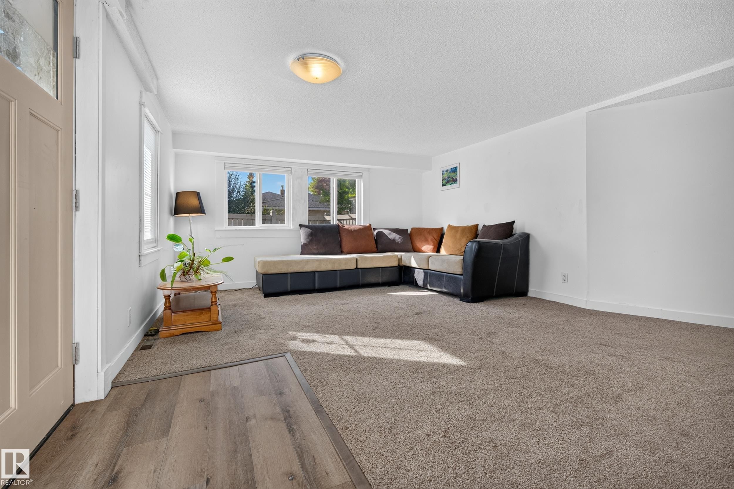 Spacious interior with neutral carpeting and wood-finish flooring - 11603 72 Avenue Nw, Edmonton, AB
