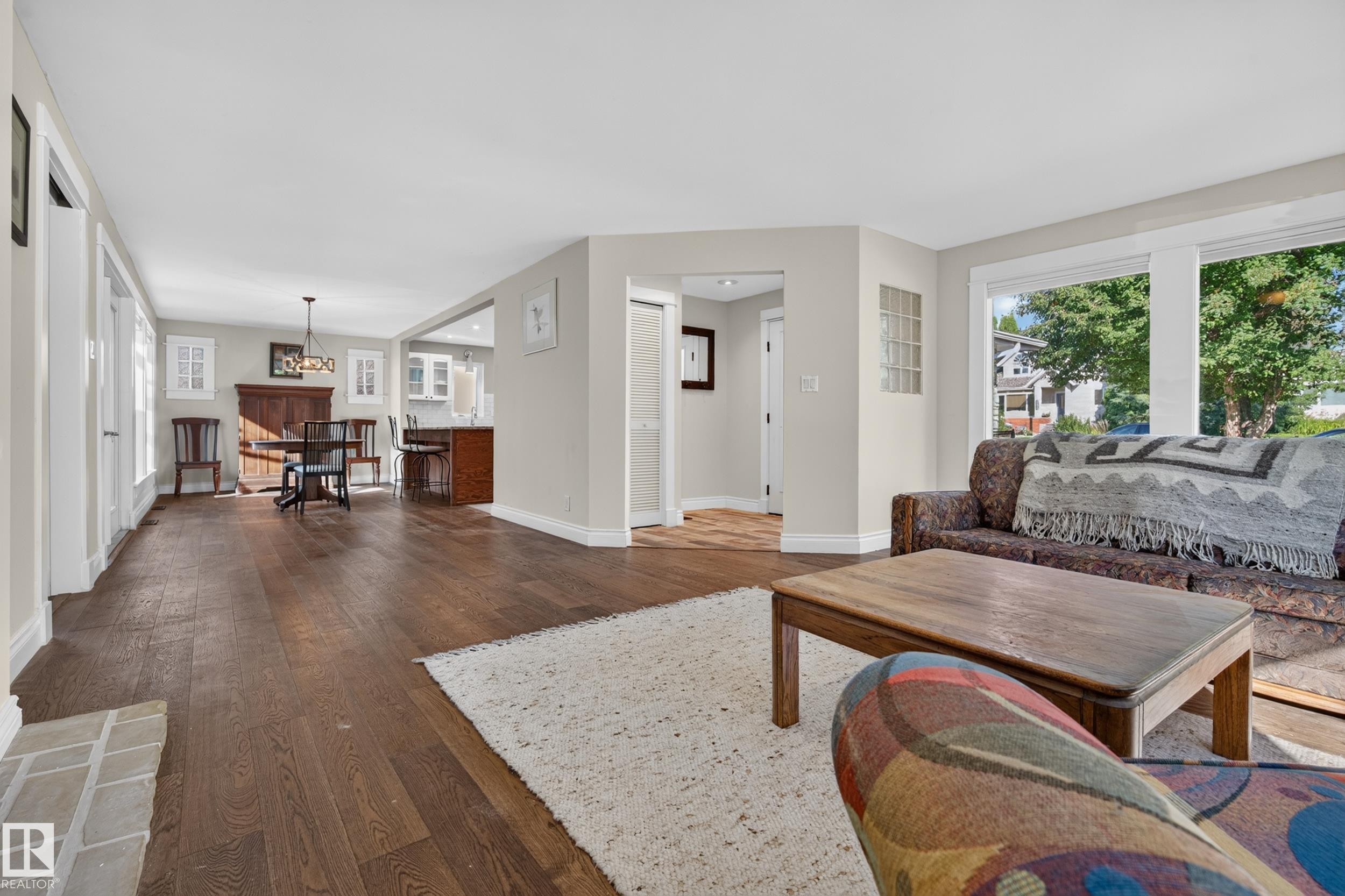 Expansive wood-finish flooring throughout, bright white trim, recessed lighting, and a kitchen featuring a peninsula - 11603 72 Avenue Nw, Edmonton, AB