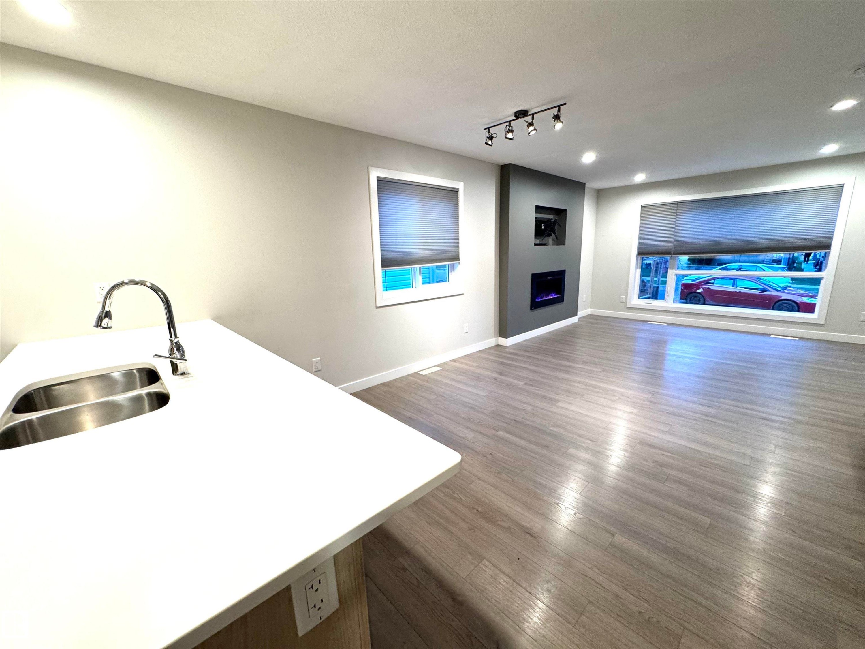 White countertop with integrated double basin sink and gooseneck faucet - 12046 89 Street Nw, Edmonton, AB