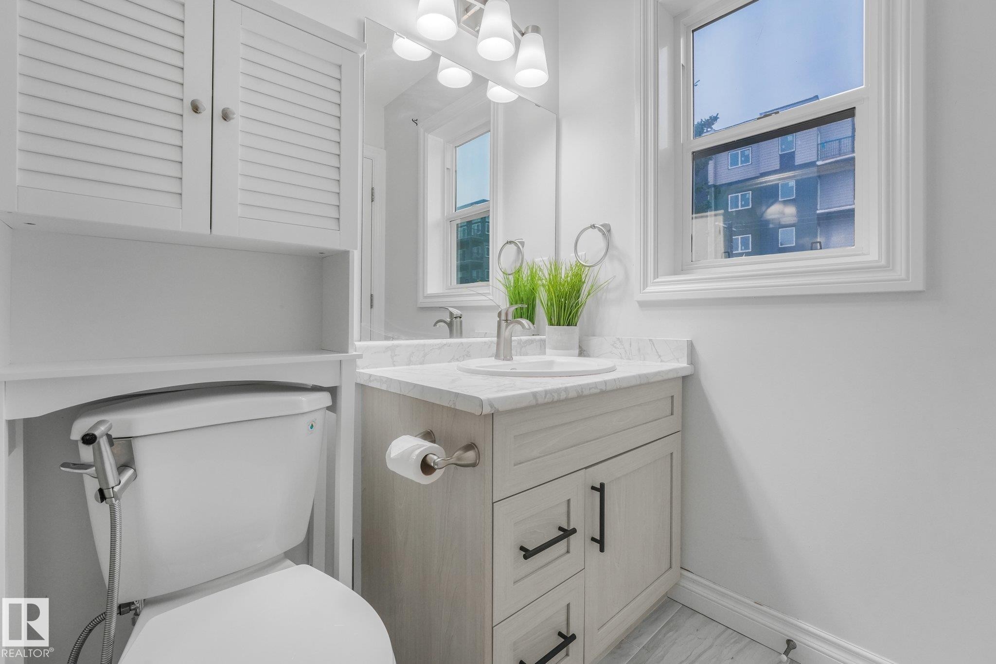 White shaker vanity with a light-toned countertop and integrated sink - 12843 67 Street Nw, Edmonton, AB