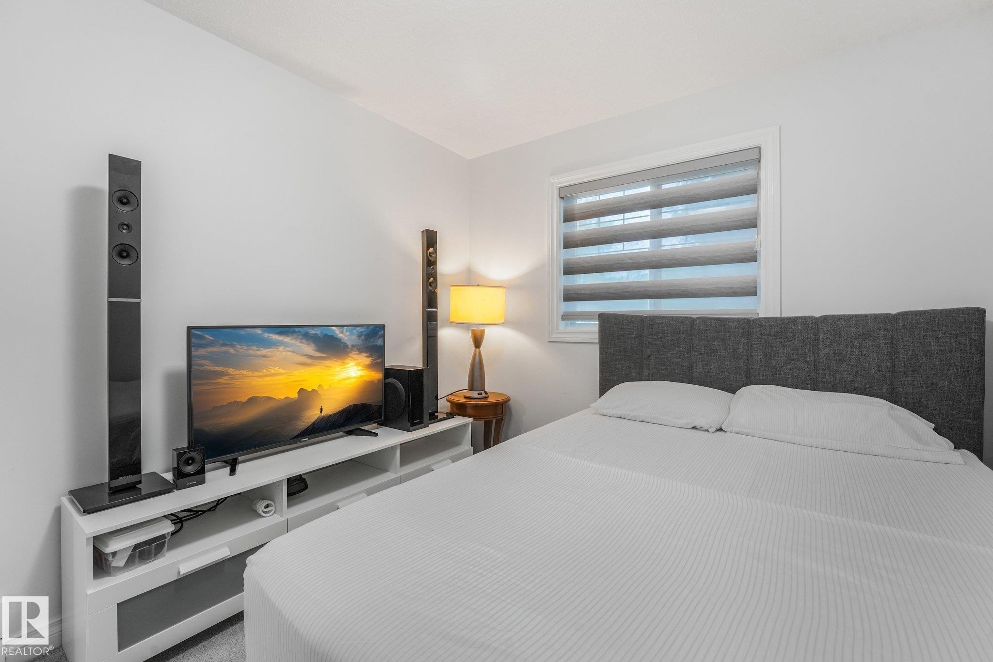Neutral wall paint, built-in window with horizontal blinds, and a built-in media console with open shelving - 12843 67 Street Nw, Edmonton, AB