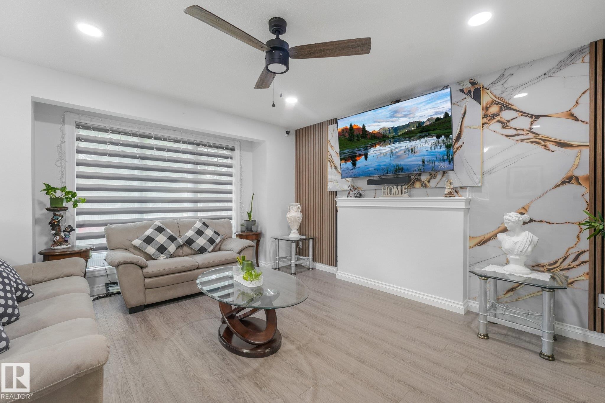 Recessed lighting, wood-finish flooring, ceiling fan, decorative accent wall, and a built-in mantel - 12843 67 Street Nw, Edmonton, AB