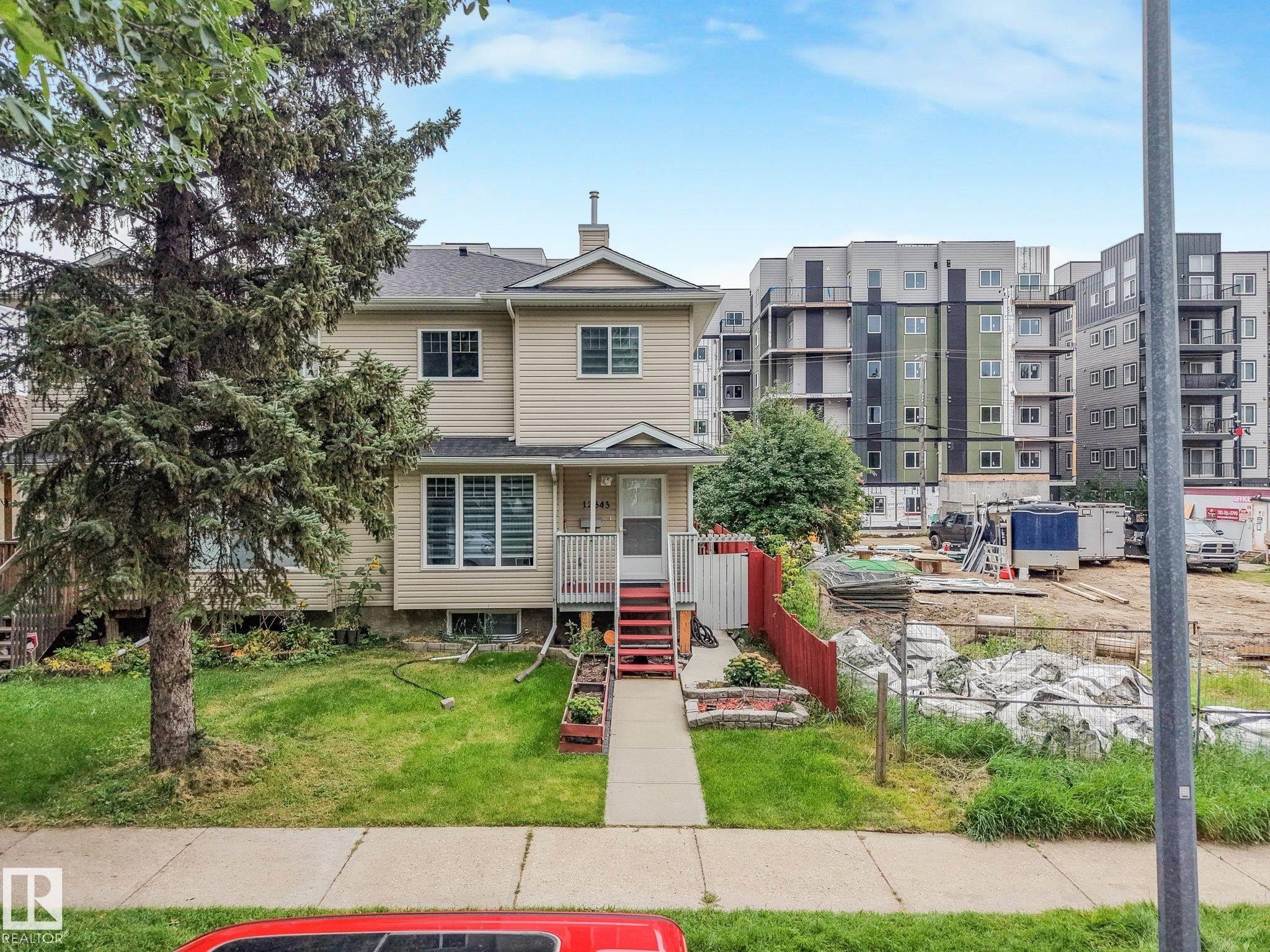 Siding exterior with multiple windows, front porch with railings, and a concrete walkway - 12843 67 Street Nw, Edmonton, AB