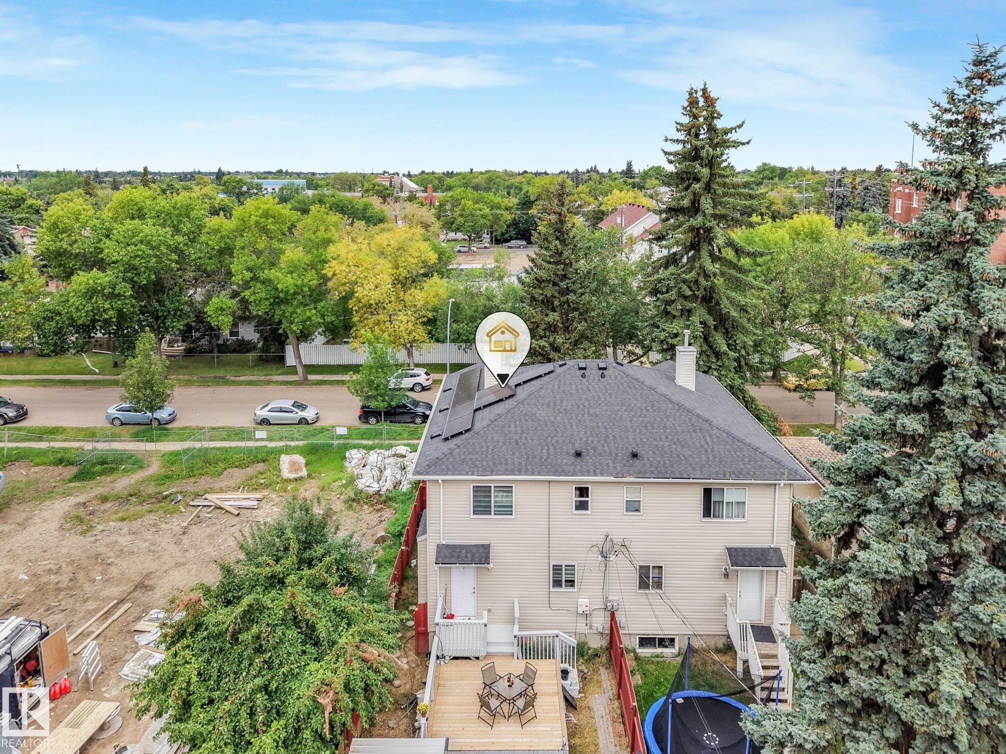 Property featuring solar panels, a dark shingle roof, and a rear wood deck - 12843 67 Street Nw, Edmonton, AB