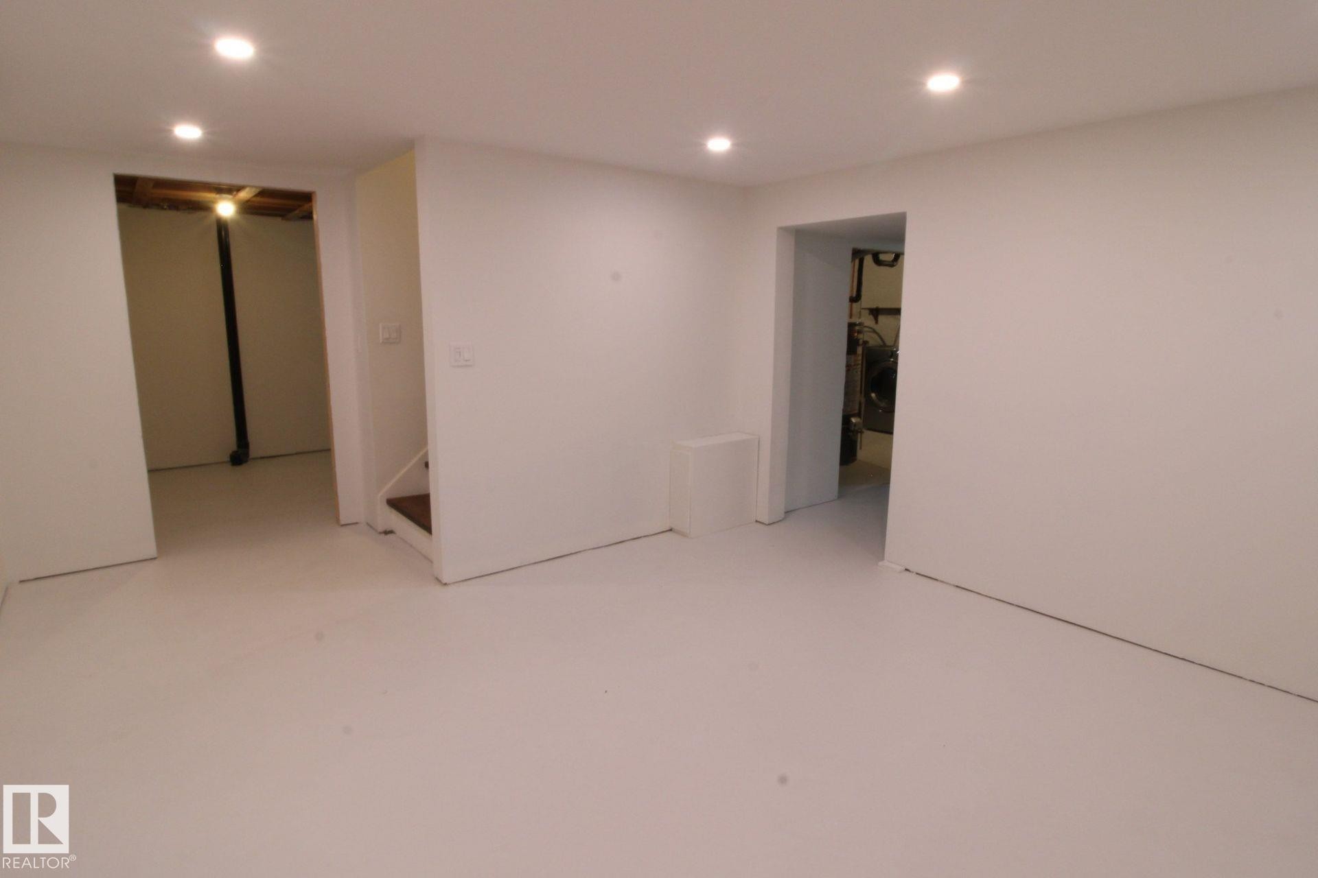 Recessed ceiling lighting, light-toned flooring, white painted walls, and open doorways - 4224 110 Street Nw, Edmonton, AB