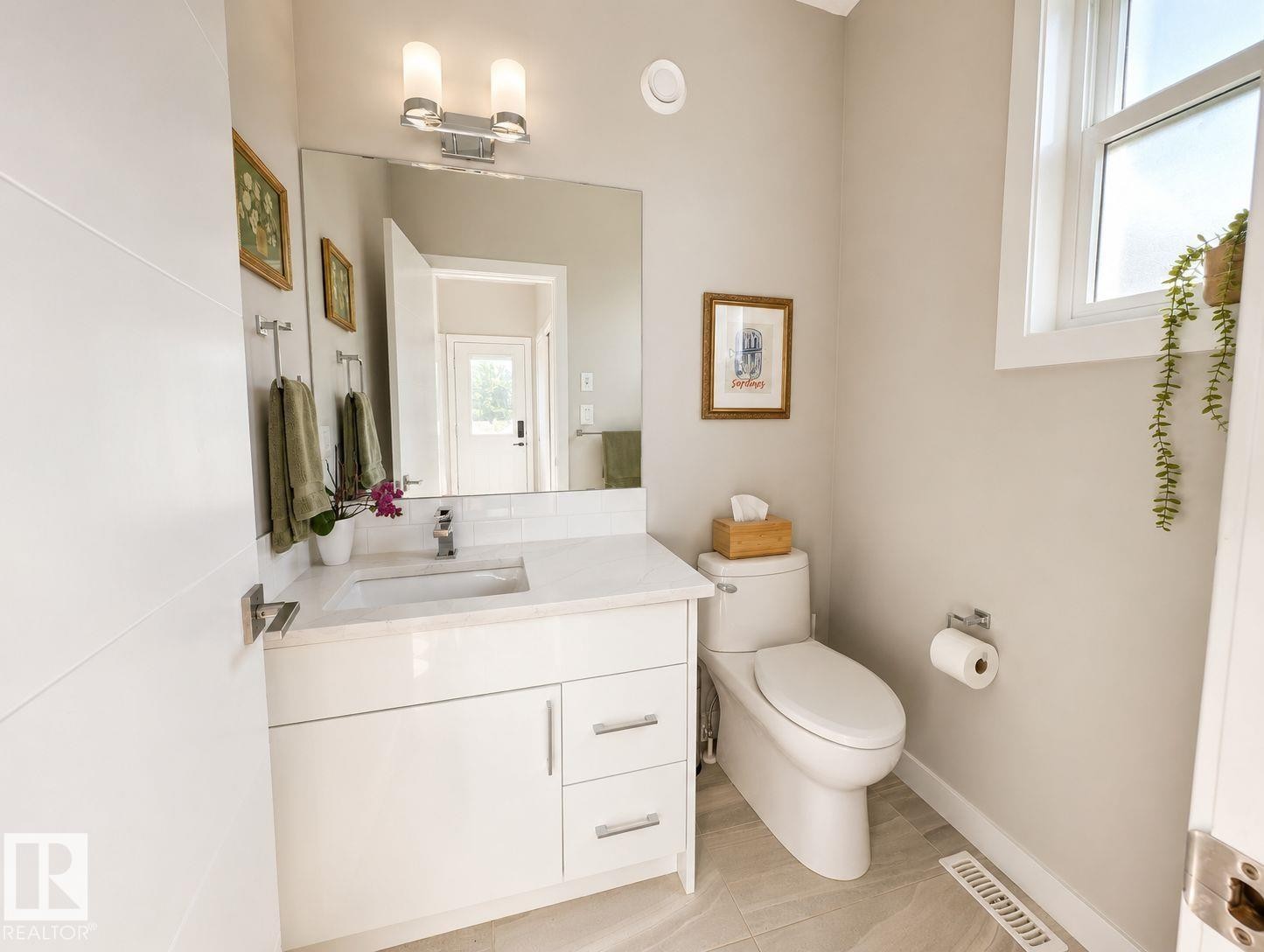 White vanity with a light-toned countertop, rectangular undermount sink, and chrome faucet - 10516 76 Street Nw, Edmonton, AB