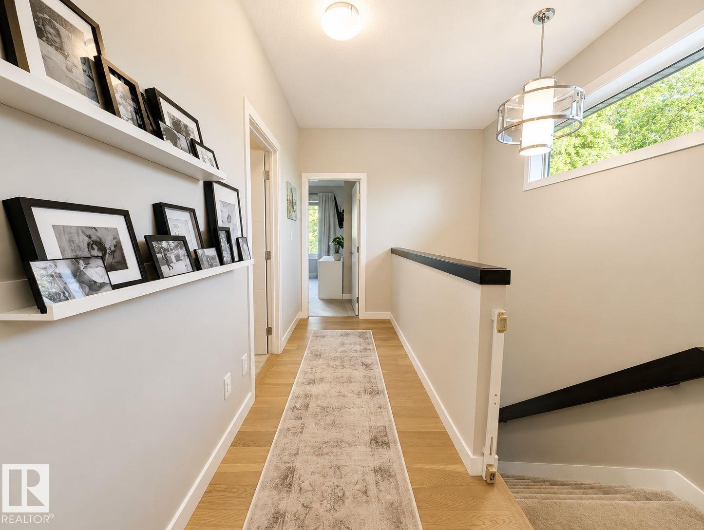 Hardwood flooring, recessed ceiling light, modern chandelier, upper transom window, and built-in wall shelving - 10516 76 Street Nw, Edmonton, AB