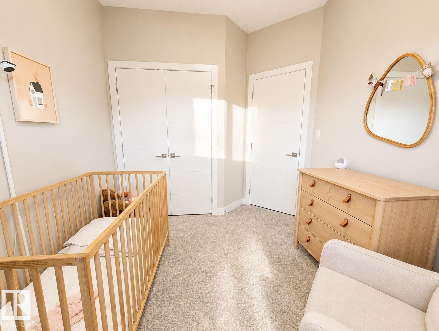 Neutral wall paint, carpeted flooring, two white panel doors, and modern door hardware - 10516 76 Street Nw, Edmonton, AB