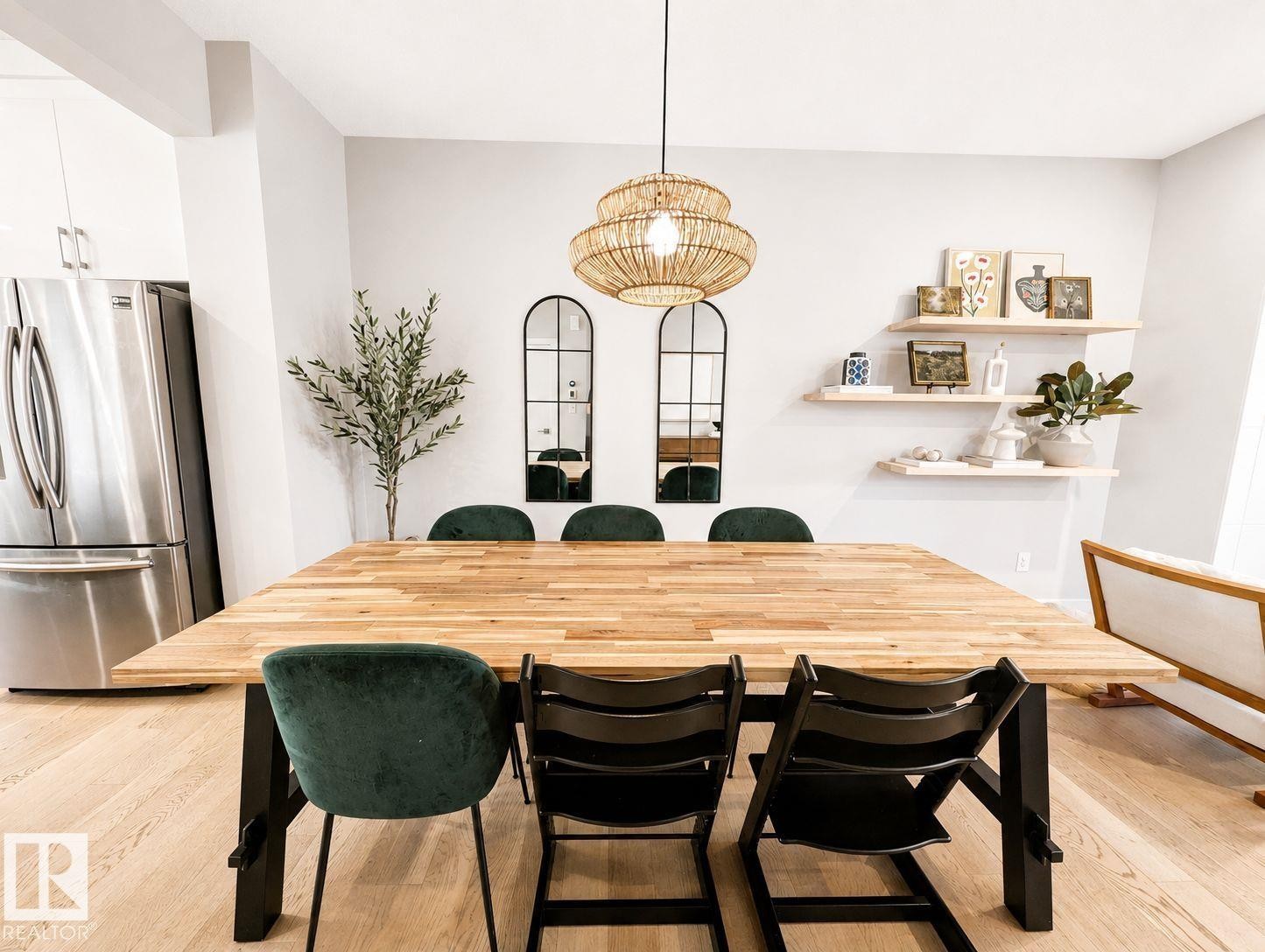 Light wood-finish flooring with a multi-tiered woven pendant light fixture - 10516 76 Street Nw, Edmonton, AB