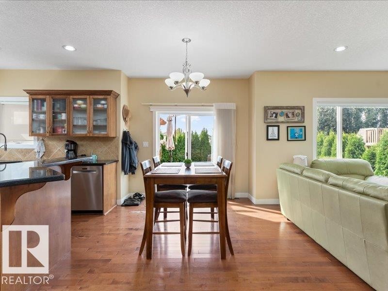 Wood-finish flooring throughout, recessed lighting, and a modern chandelier - 496 Ravine Court, Devon, AB