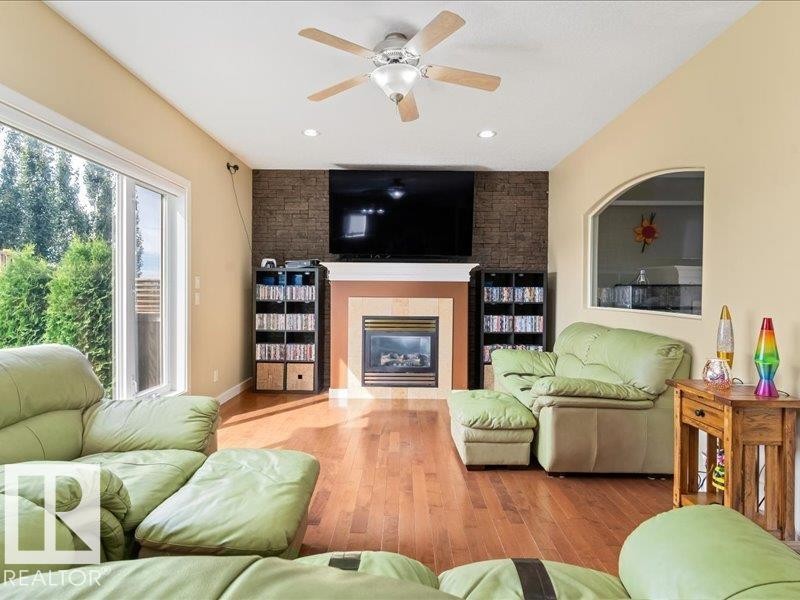 Hardwood-finish flooring, recessed lighting, and a stone-clad fireplace with a decorative mantel - 496 Ravine Court, Devon, AB
