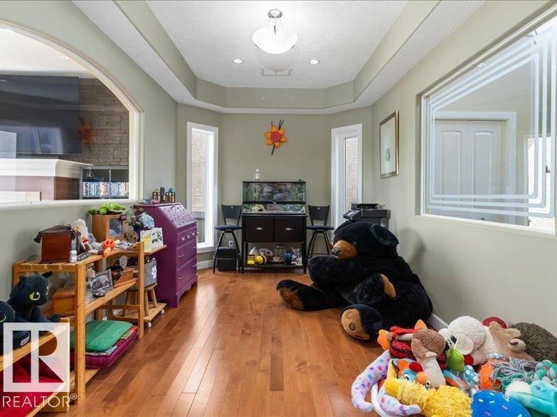 Wood-finish flooring with a multi-level ceiling design - 496 Ravine Court, Devon, AB