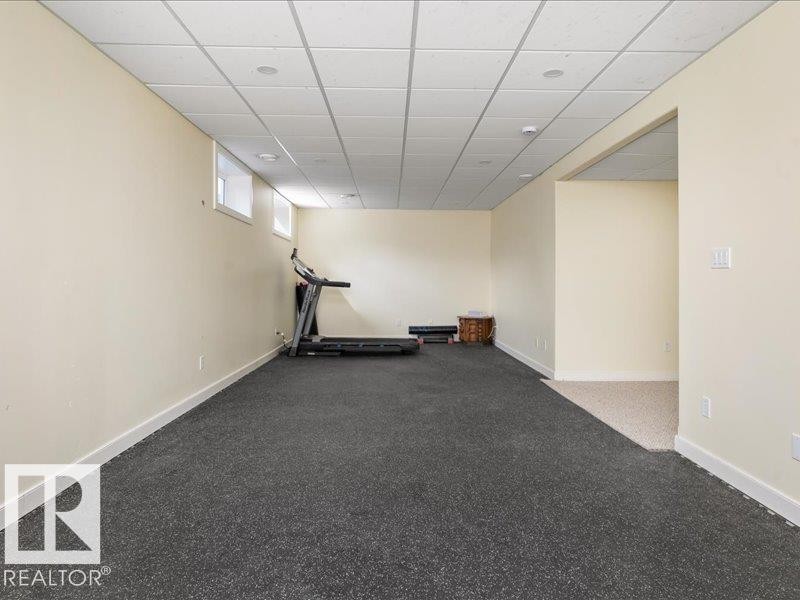 Spacious room featuring neutral painted walls, recessed lighting, and a drop ceiling - 496 Ravine Court, Devon, AB