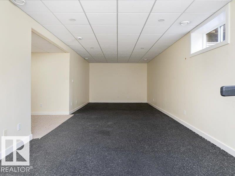 Recessed lighting, drop ceiling, neutral wall tones, window, and dark flooring - 496 Ravine Court, Devon, AB