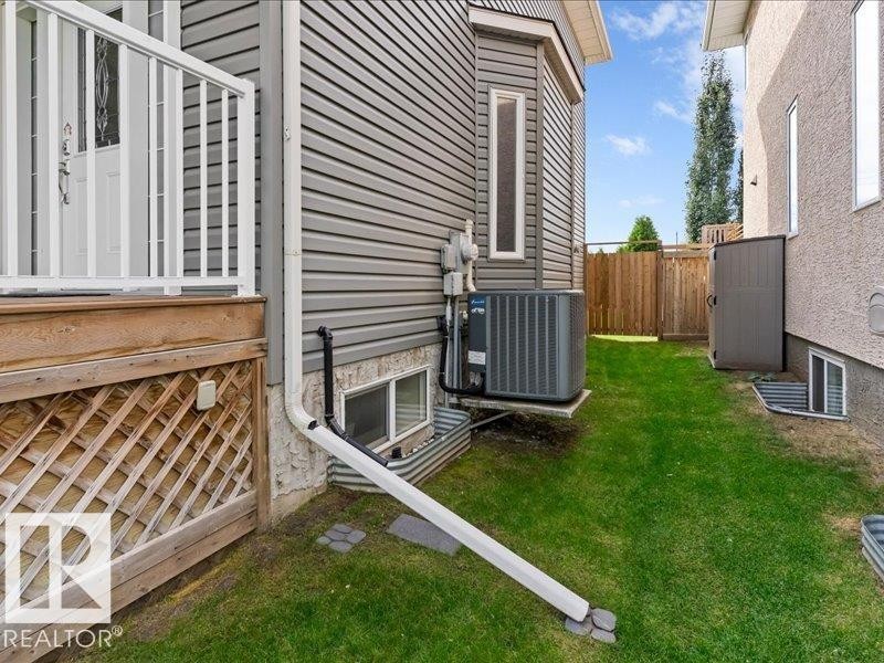 Gray horizontal siding exterior with a white deck railing, wooden lattice deck skirting, and a fenced perimeter - 496 Ravine Court, Devon, AB
