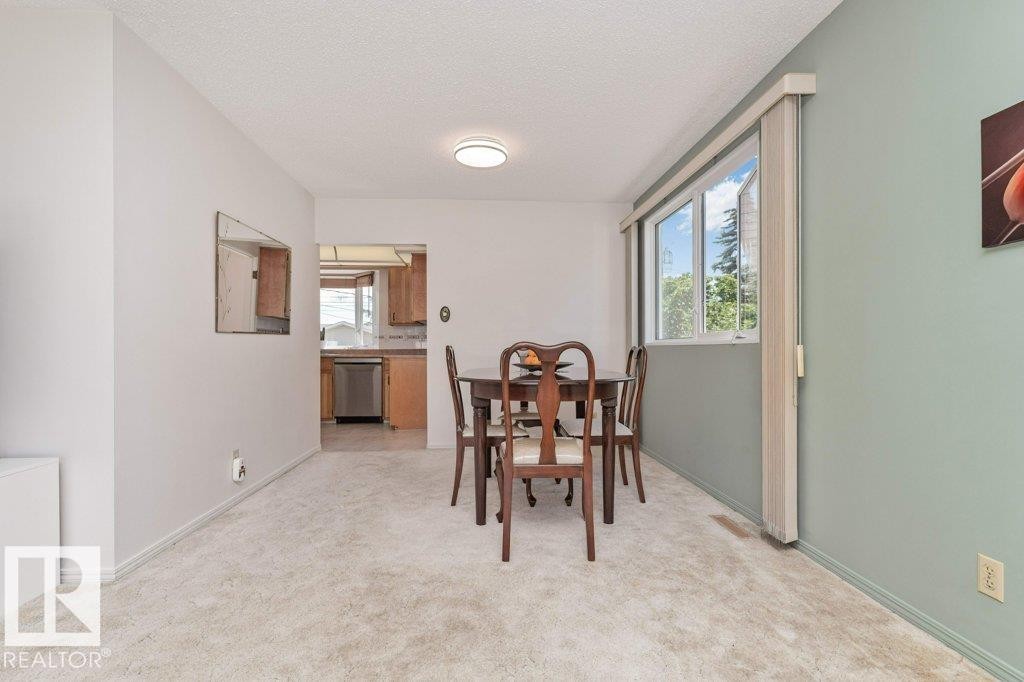 Open-concept dining area featuring a carpeted floor, recessed lighting, and a broad window - 11415 56 Avenue Nw, Edmonton, AB